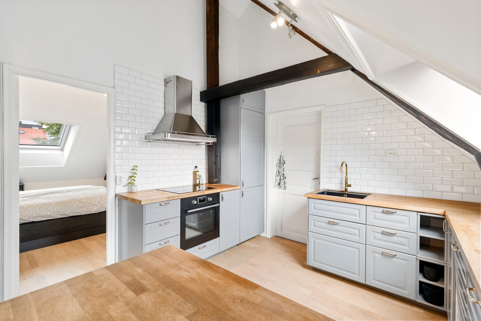 Pent kjøkken fra 2018 med slette fronter og heltre benkeplate. Galleribilde