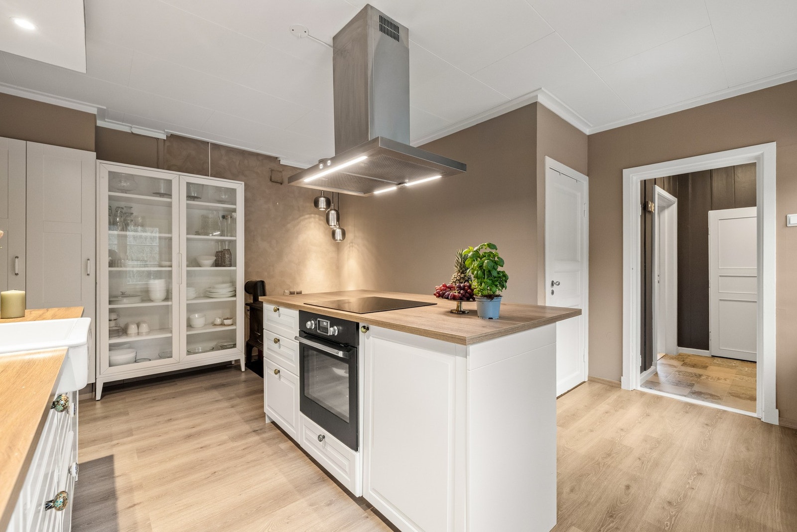 Vis a vis vasken er det kjøkkenøy med integrert stekeovn og induksjonstopp samt takhengt ventilator over. Kjøkkenøyen fungerer også som en koselig frokostplass med plass til tre barstoler. Galleribilde