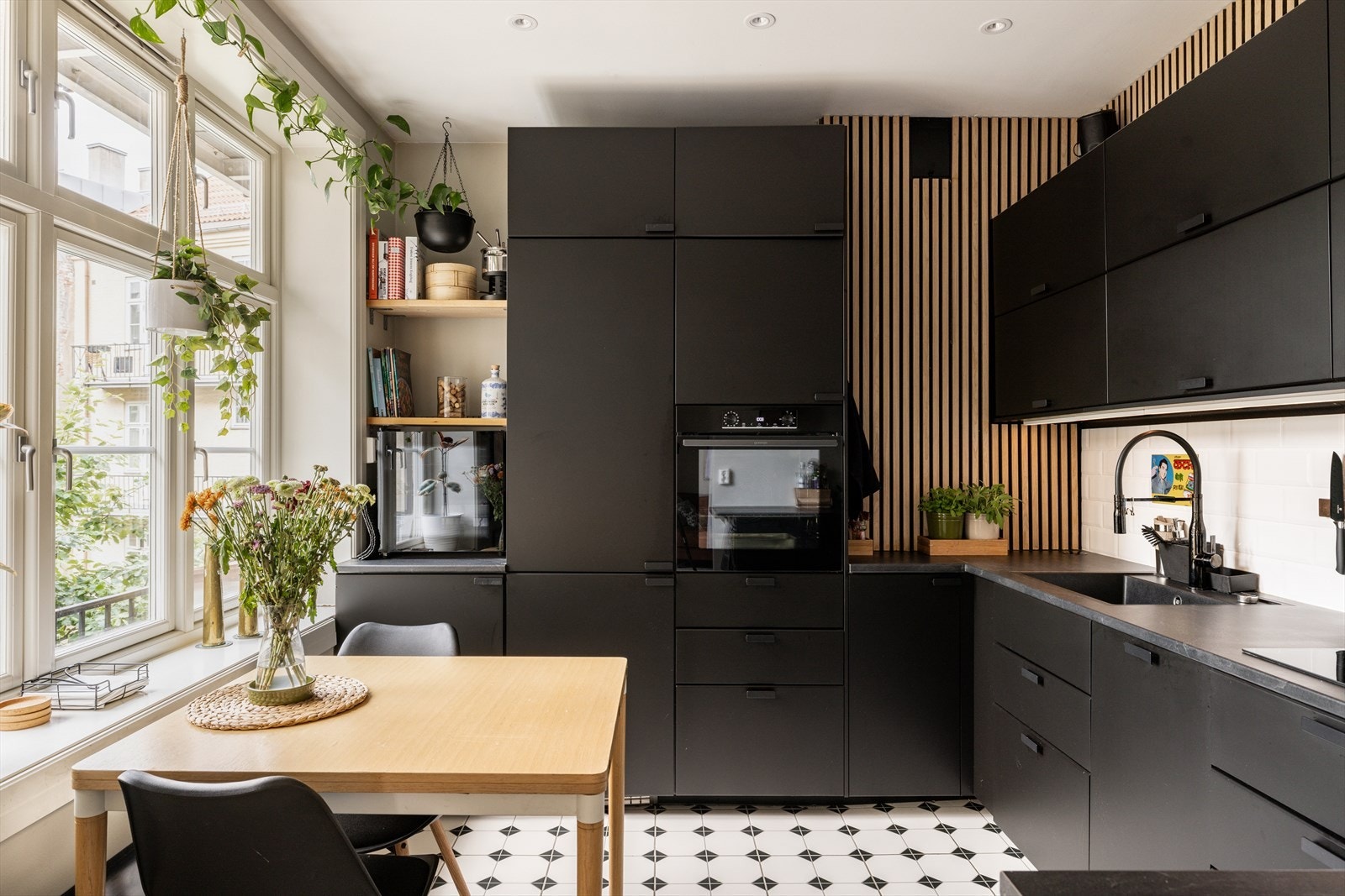 Rålekkert og moderne kjøkken, med mørke, slette fronter og laminert benkeplate med nedfelt oppvaskkum Galleribilde