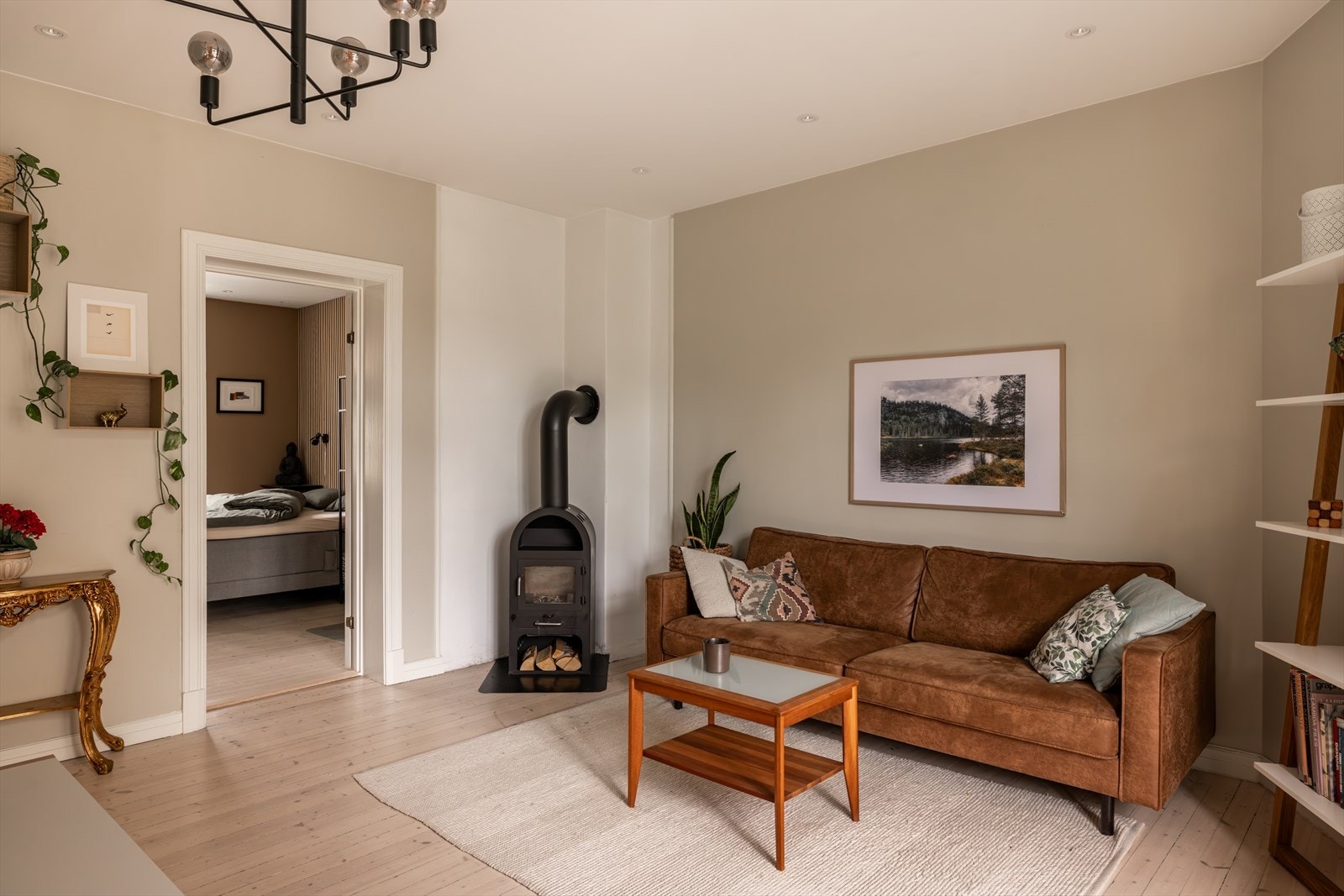 Hyggelig peis, originale tregulv og en lys fargepalett gir rommet et helhetlig uttrykk Galleribilde