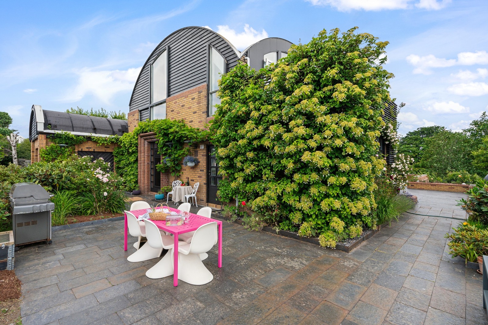 Flott fasade med teglstein og buet tak. Det er lagt skifer på uteområdene. Galleribilde