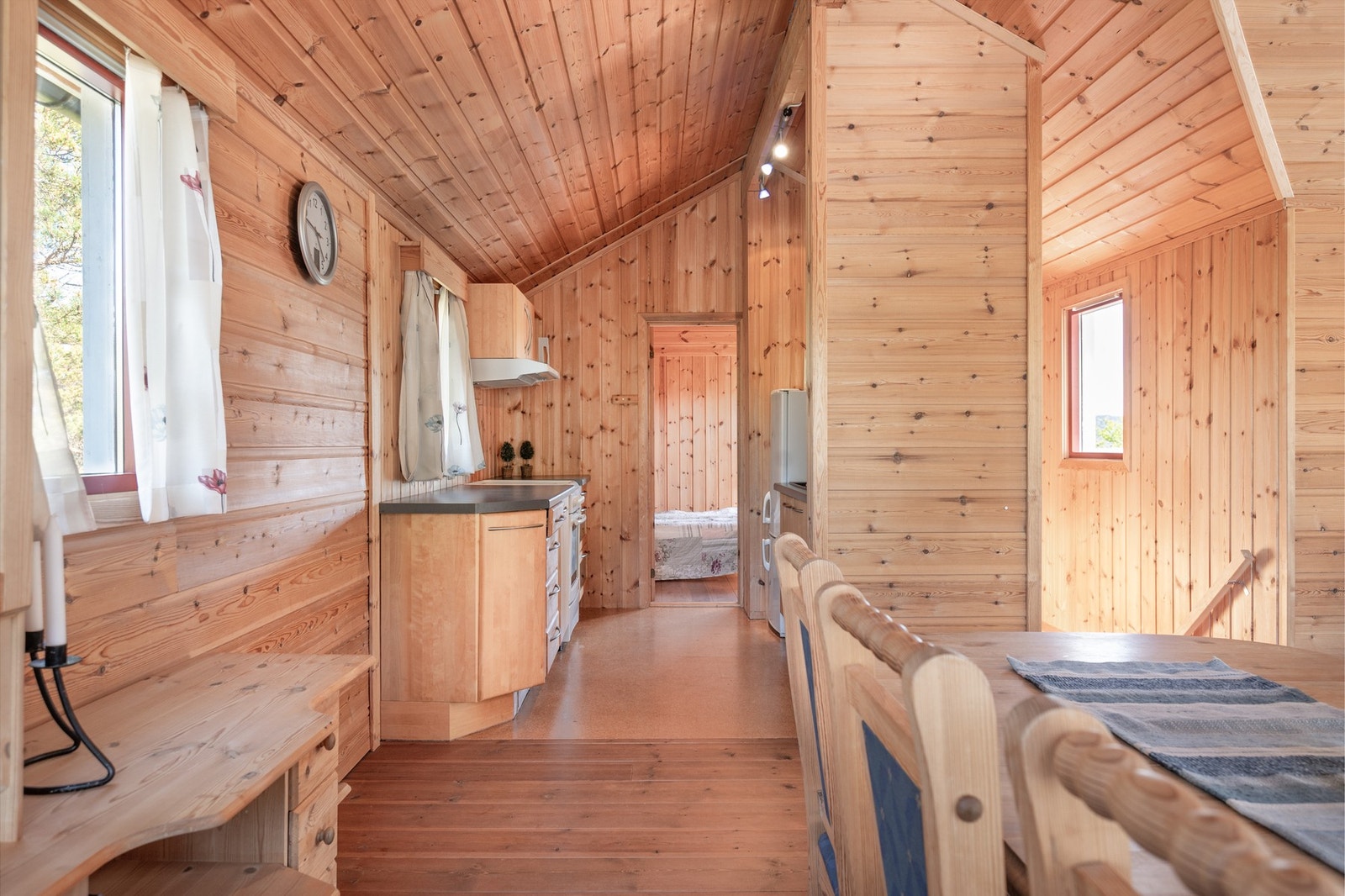 Tosidet kjøkkeninnredning med slette trefronter og sortlaminerte benkeplater. Galleribilde