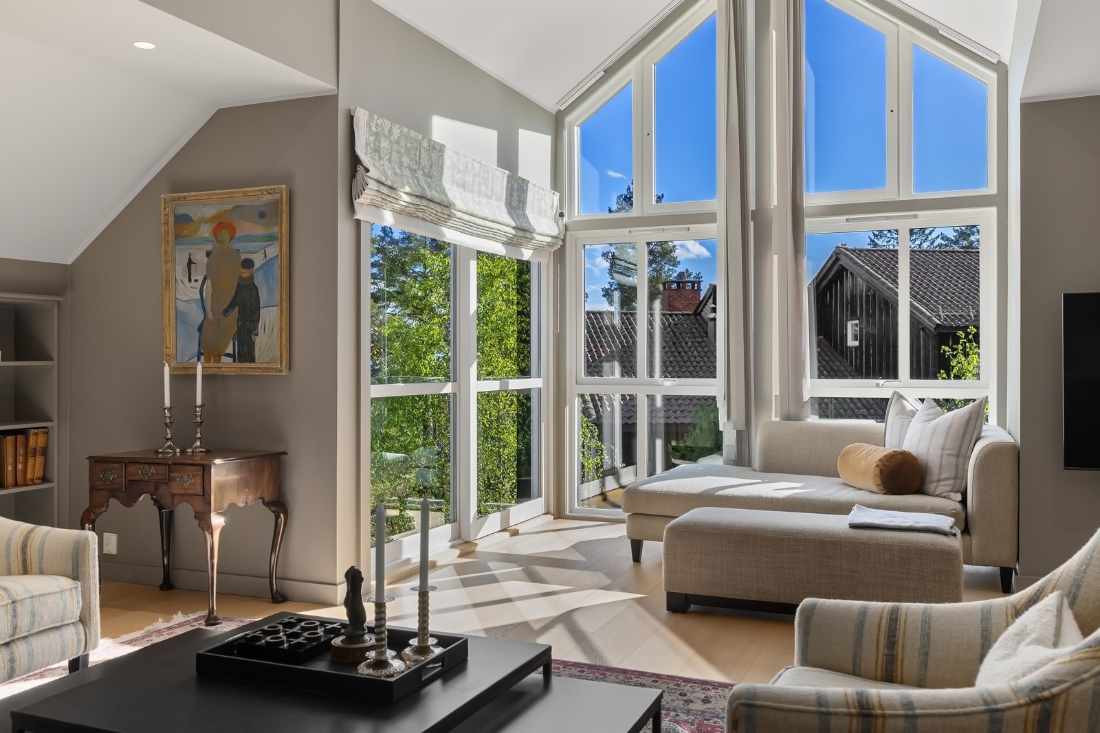 Loftsstuen har stor takhøyde og store paorama vinduer, som gir mye lys til rommet. Galleribilde