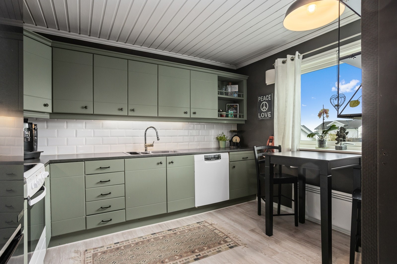 Det er kjøkkenventilator med kullfilter og frittstående hvitevarer. Galleribilde