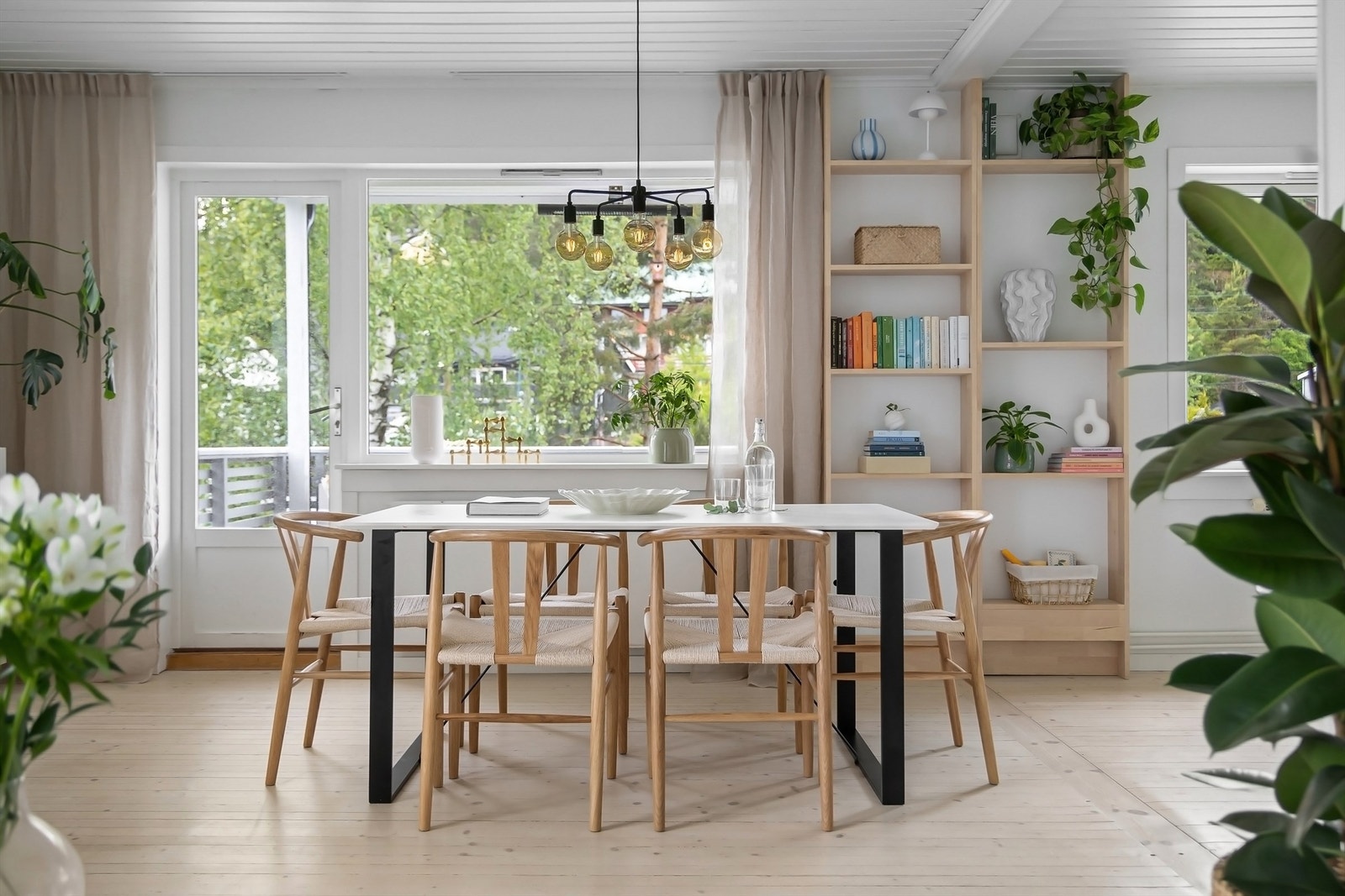 Langs de store vindusflatene er det god plass til et større spisebord som skaper en naturlig romdeler mellom stue og kjøkken Galleribilde