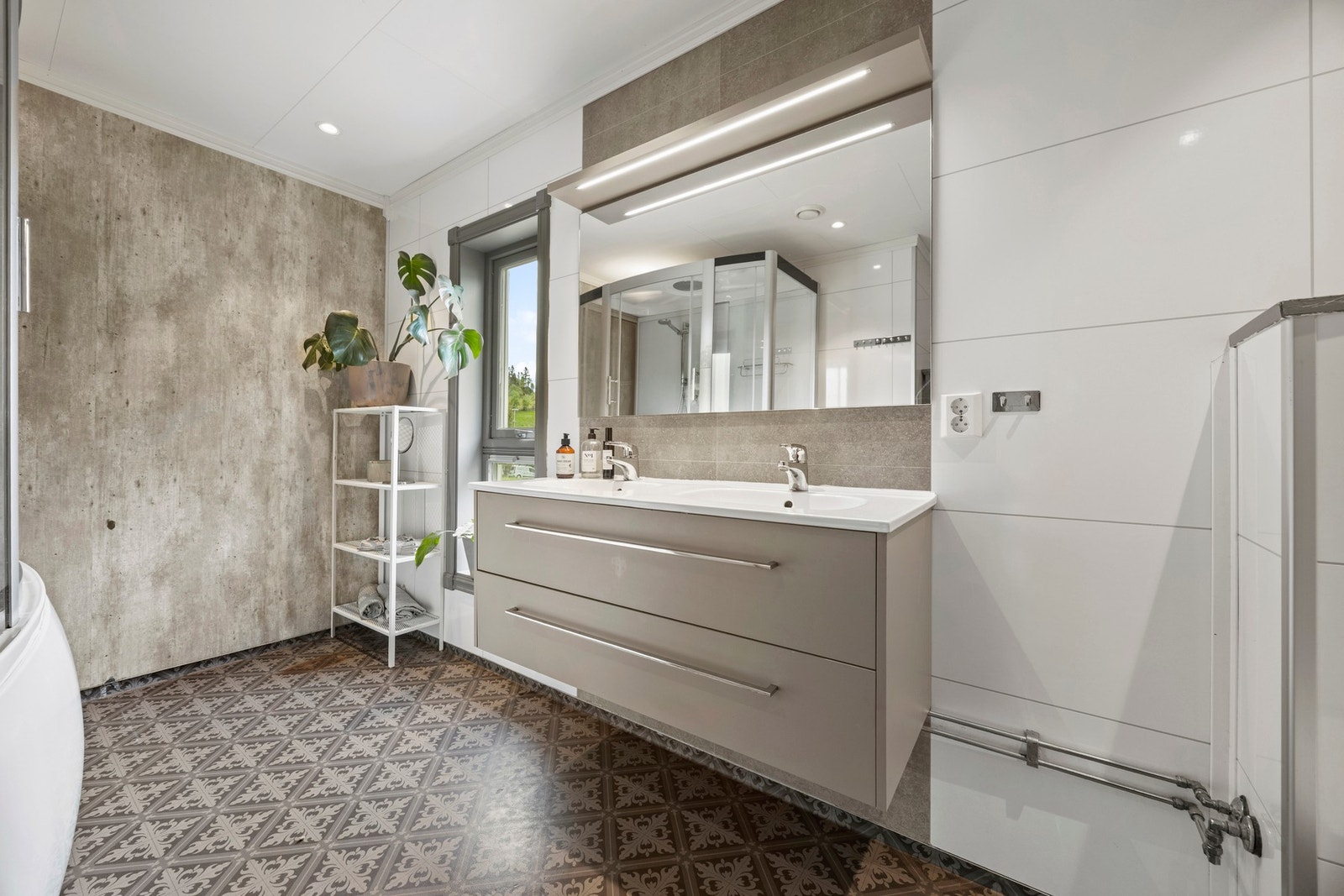 Romslig og pent bad med god plass til oppbevaringsmøblement. Galleribilde