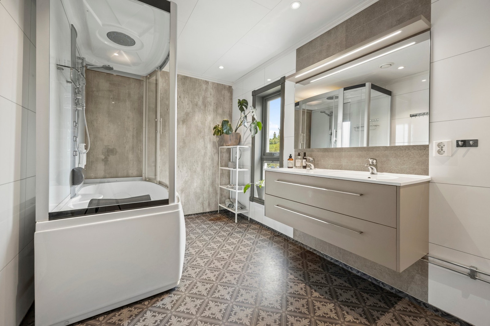 Badet har gulvvarme, og er utstyrt med bl.a. badekar/dusjkabinett, servantskap og veggmontert WC. Galleribilde