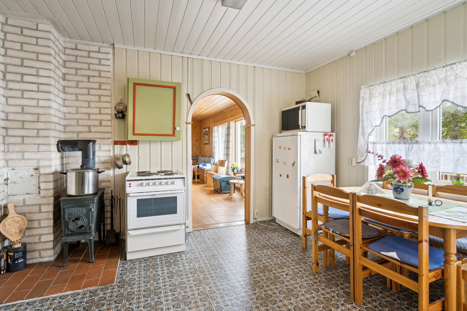 En eldre vedovn tilfører rommet en god varme. Det er også plass til en hyggelig spiseplass ved ytterveggen, hvor en klaffventil sørger for naturlig ventilasjon. Galleribilde