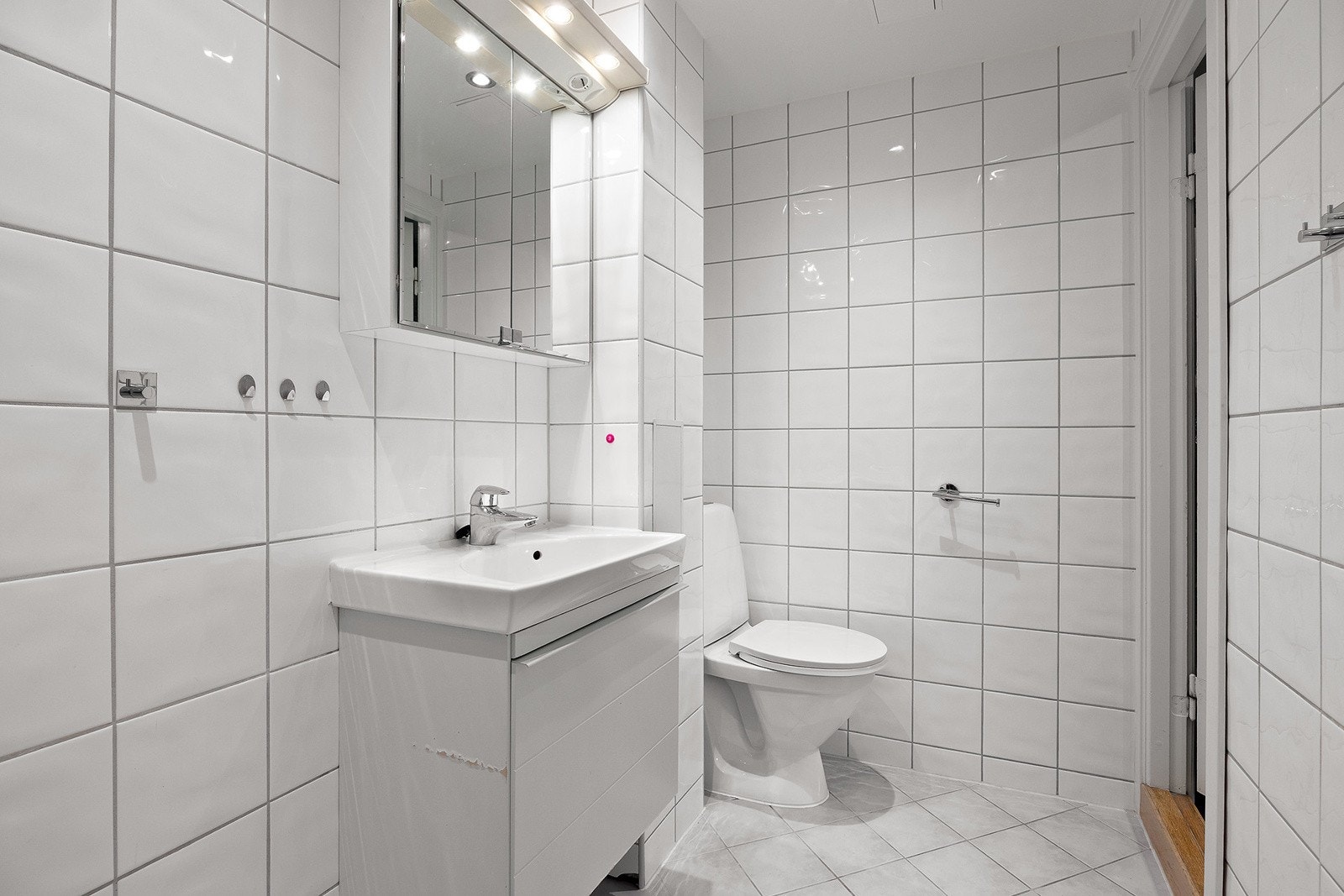 Speilskap med overlys og stikkontakt over servant. Gulvmontert toalett. Dusjhjørne med innfellbare glassdører Galleribilde