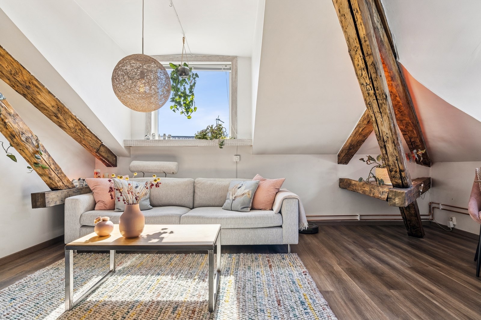 Gode vindusflater slipper inn rikelig med dagslys, og synlige trebjelker i taket gir rommet karakter Galleribilde