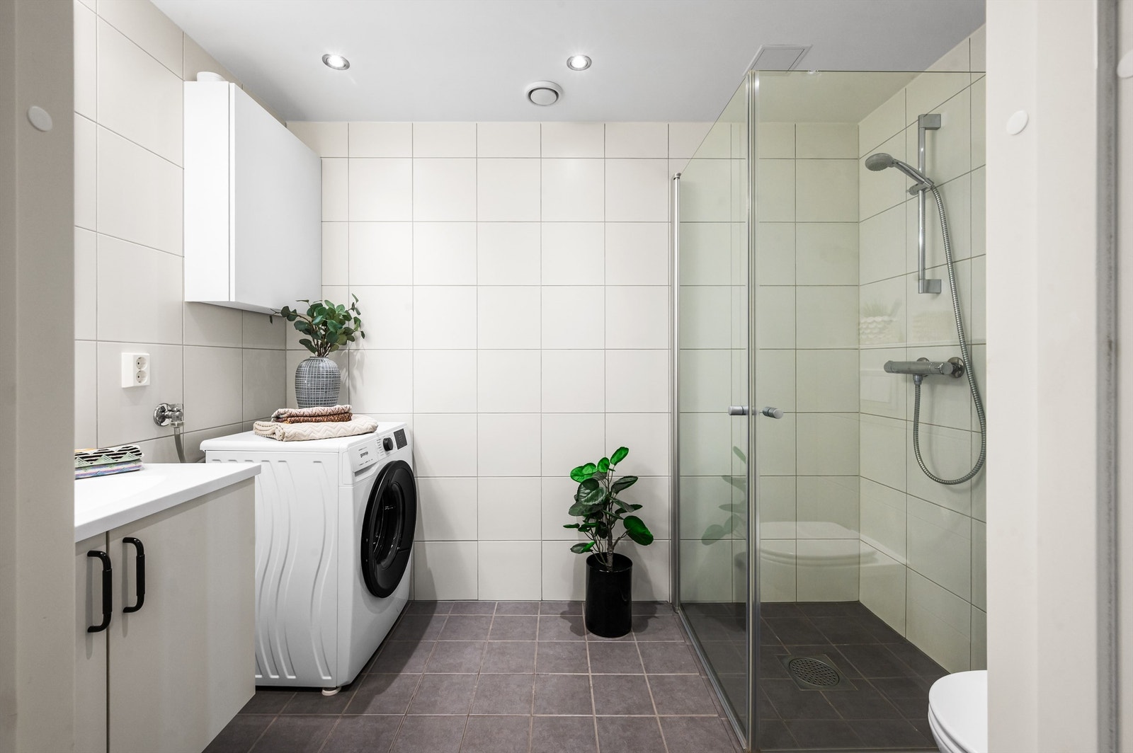 Badet er pent flislagt på gulv og vegger med varme i gulvet. Innredningen består av vegghengt servantinnredning med servant. Over servanten er det et fint speil med belysning. Galleribilde