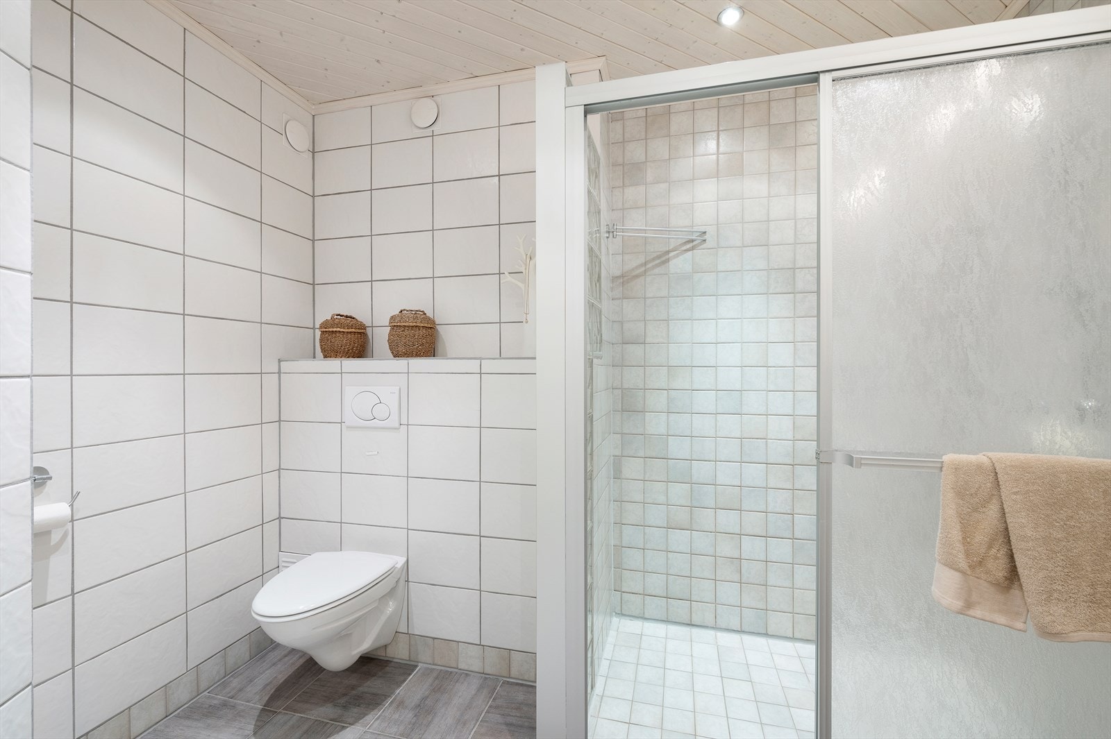 Baderommet er utstyrt med blant annet gulvvarme, downlights i himling, mekanisk avtrekk, dusjnisje, servant, servantskap og veggmontert wc. Galleribilde