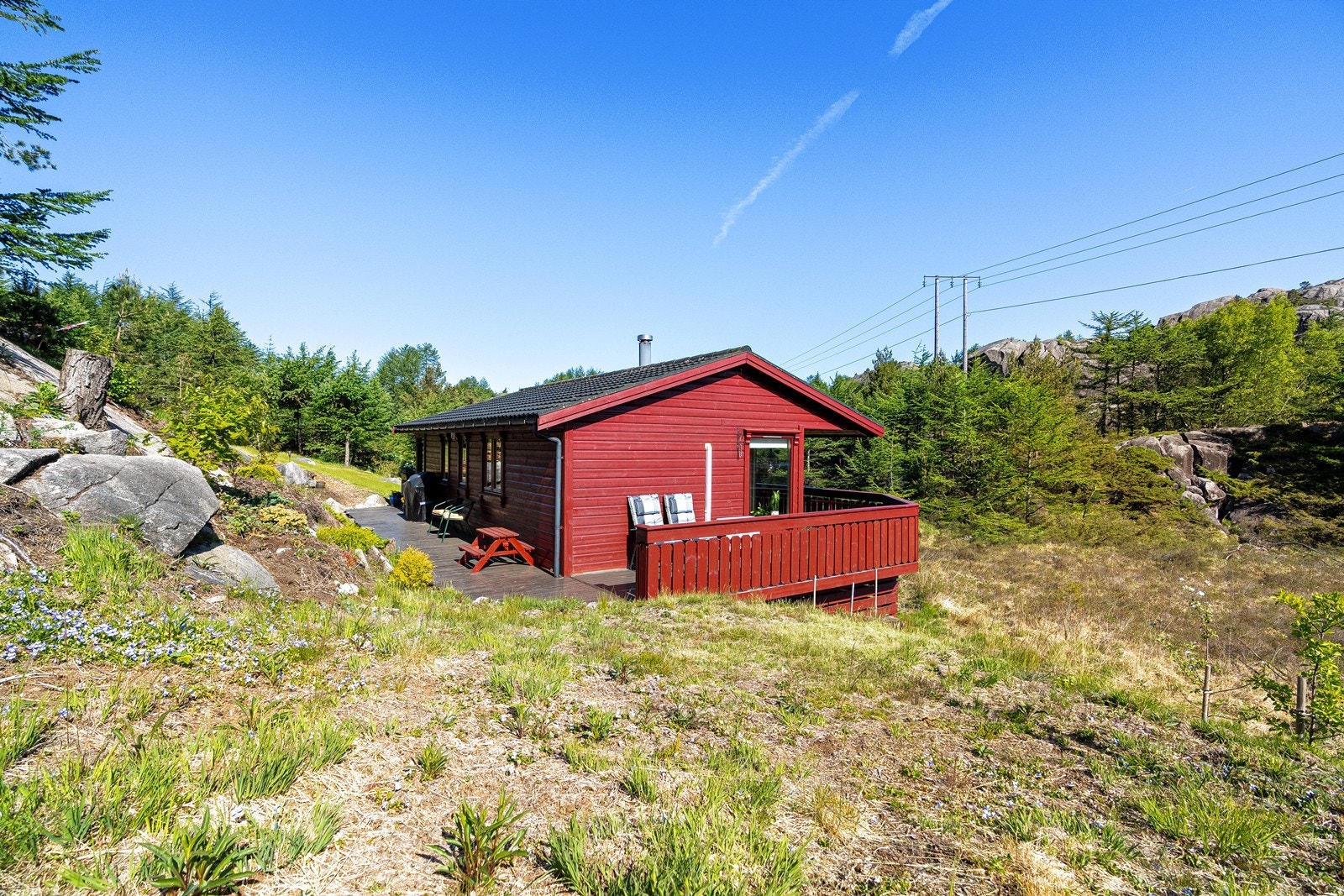 Trivelig uteområde med plen, beplantning og terrasser rundt hytta Galleribilde