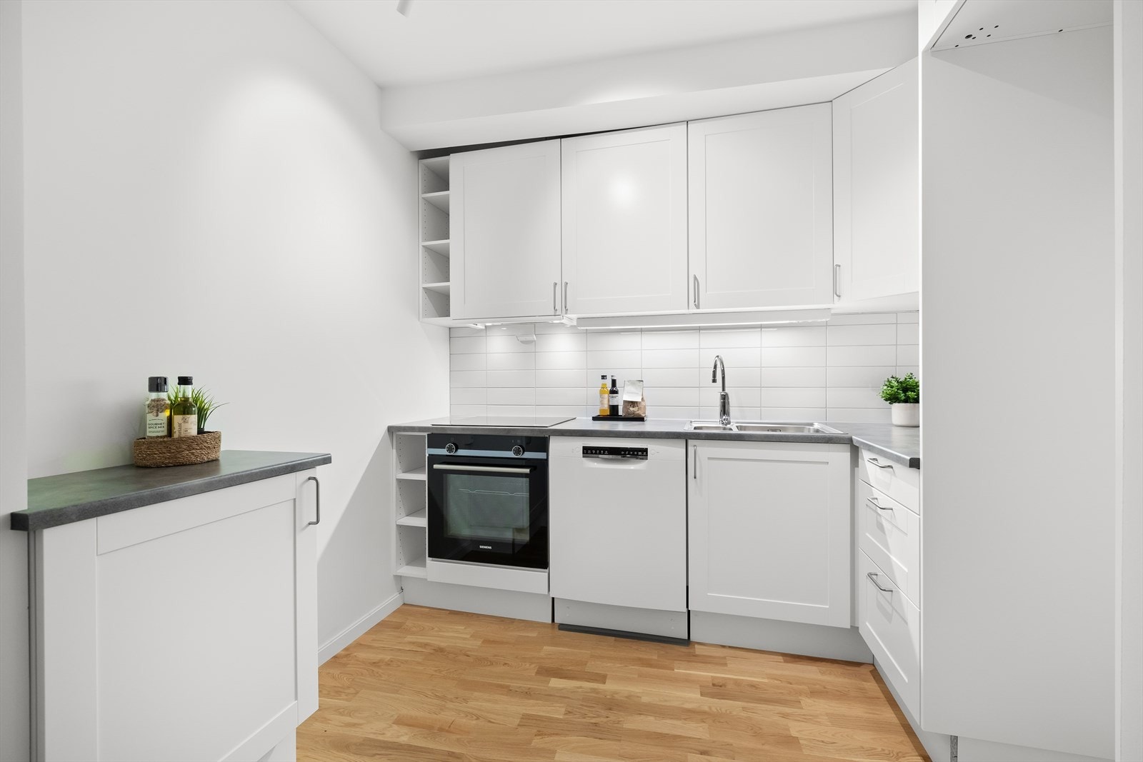 Videre er det takhøye overskap, belysning over benkeplate og ventilator over kokeplassen. Galleribilde