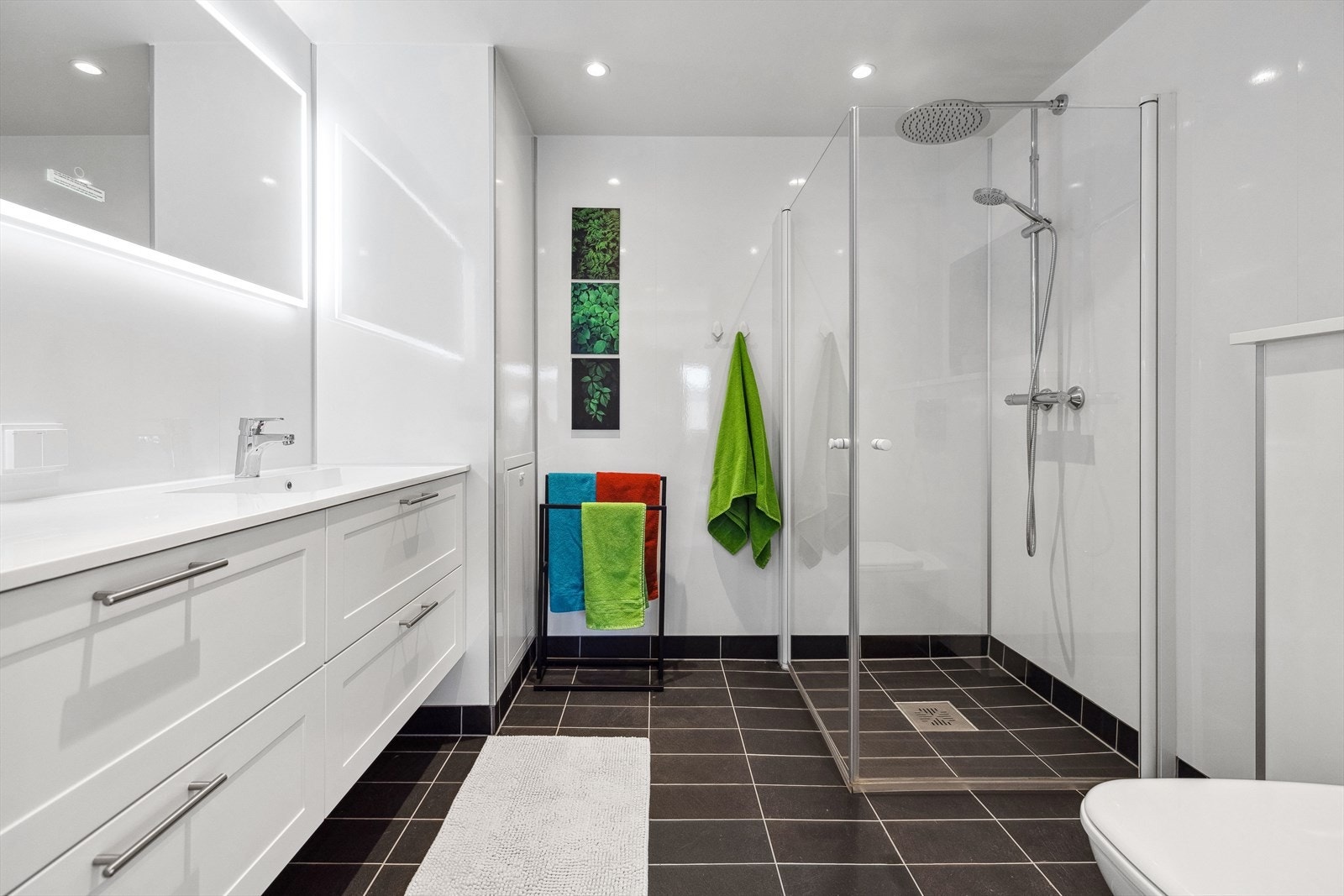 Leiligheten har et romslig og lyst bad med flislagt gulv og baderomsplater på veggene. Galleribilde