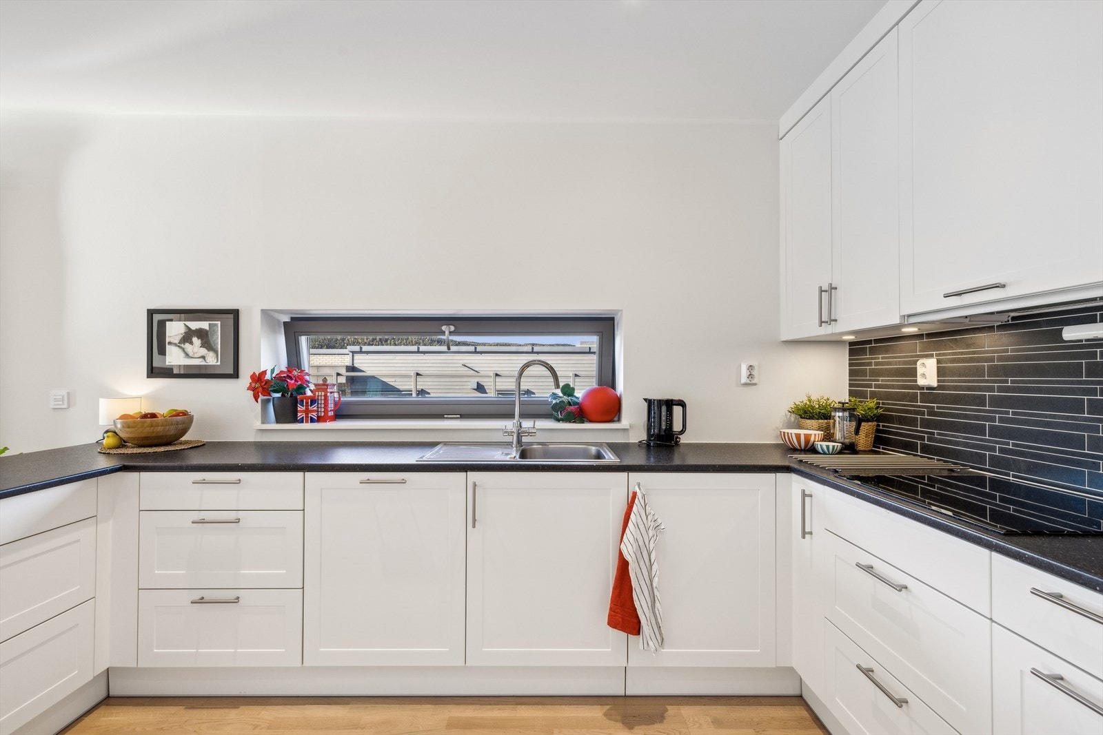 Innredningen har stilrene profilerte fronter og en mørk laminatbenkeplate som skaper en fin kontrast. Galleribilde