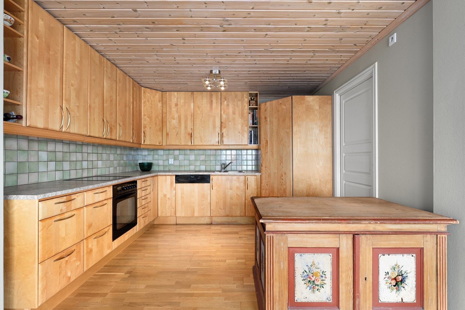 Kjøkkenet inneholder stekovn, platetopp, oppvaskmaskin og praktisk kjølehjørne Galleribilde