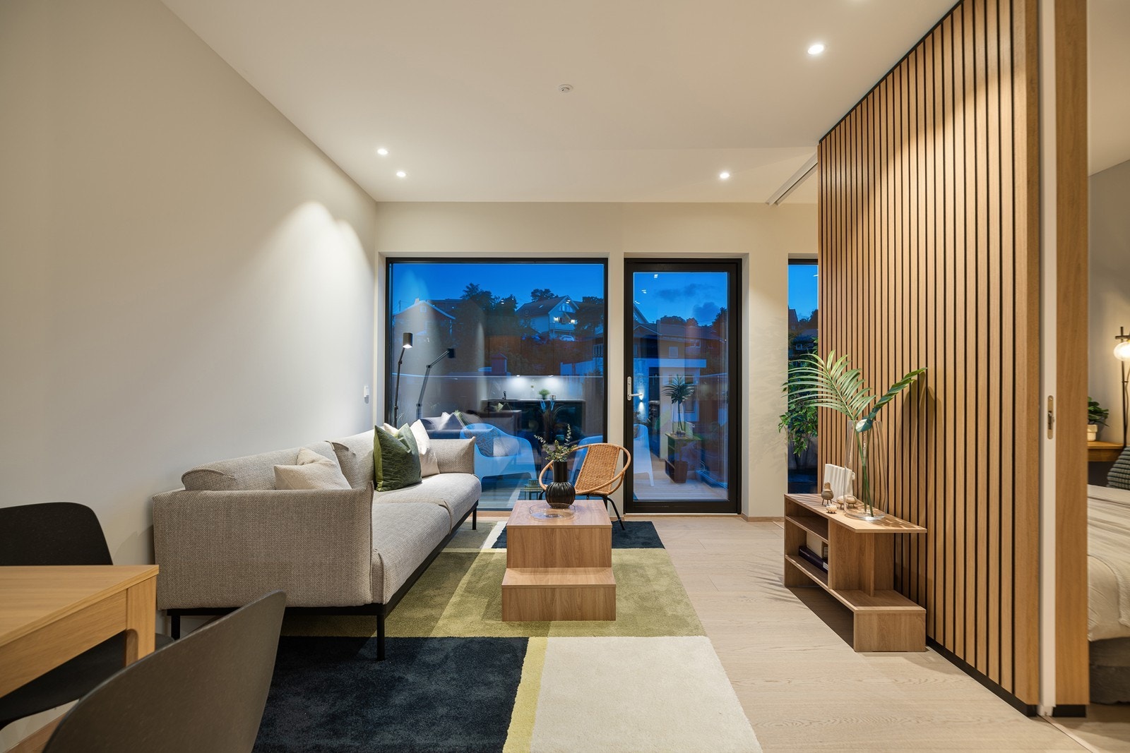 Lys og åpen stue- og kjøkkenløsning med god takhøyde, 1stavs parkett på gulv og hvitmalte gipsvegger (listefritt i overgang tak/vegg) og spotter i tak Galleribilde