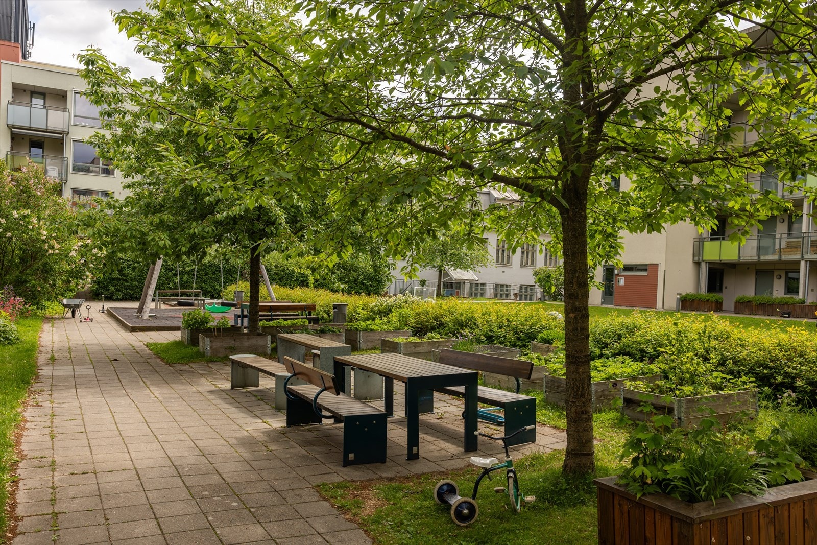 Bakgården er opparbeidet med flere sittegrupper, diverse beplantning og gressplen. Galleribilde