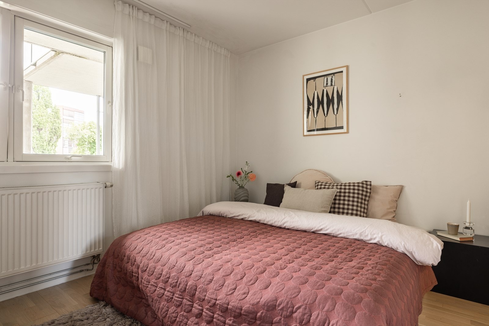 Et romslig soverom med god plass til stor dobbeltseng og nattbord på hver side. Galleribilde