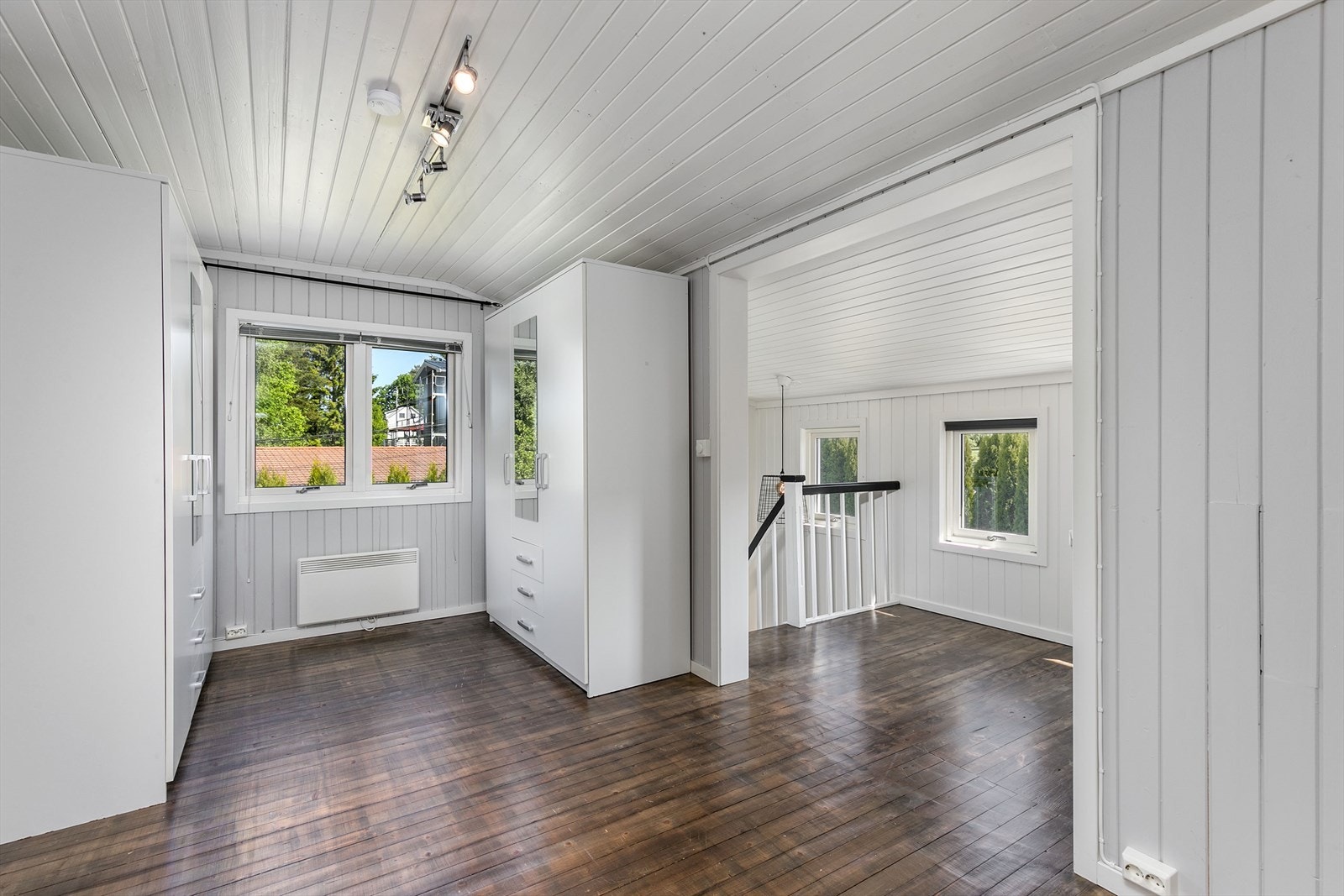 I loftsetasjen kommer du først opp i en gang med loftstue innredet som garderobe med originale heltregulv. Galleribilde