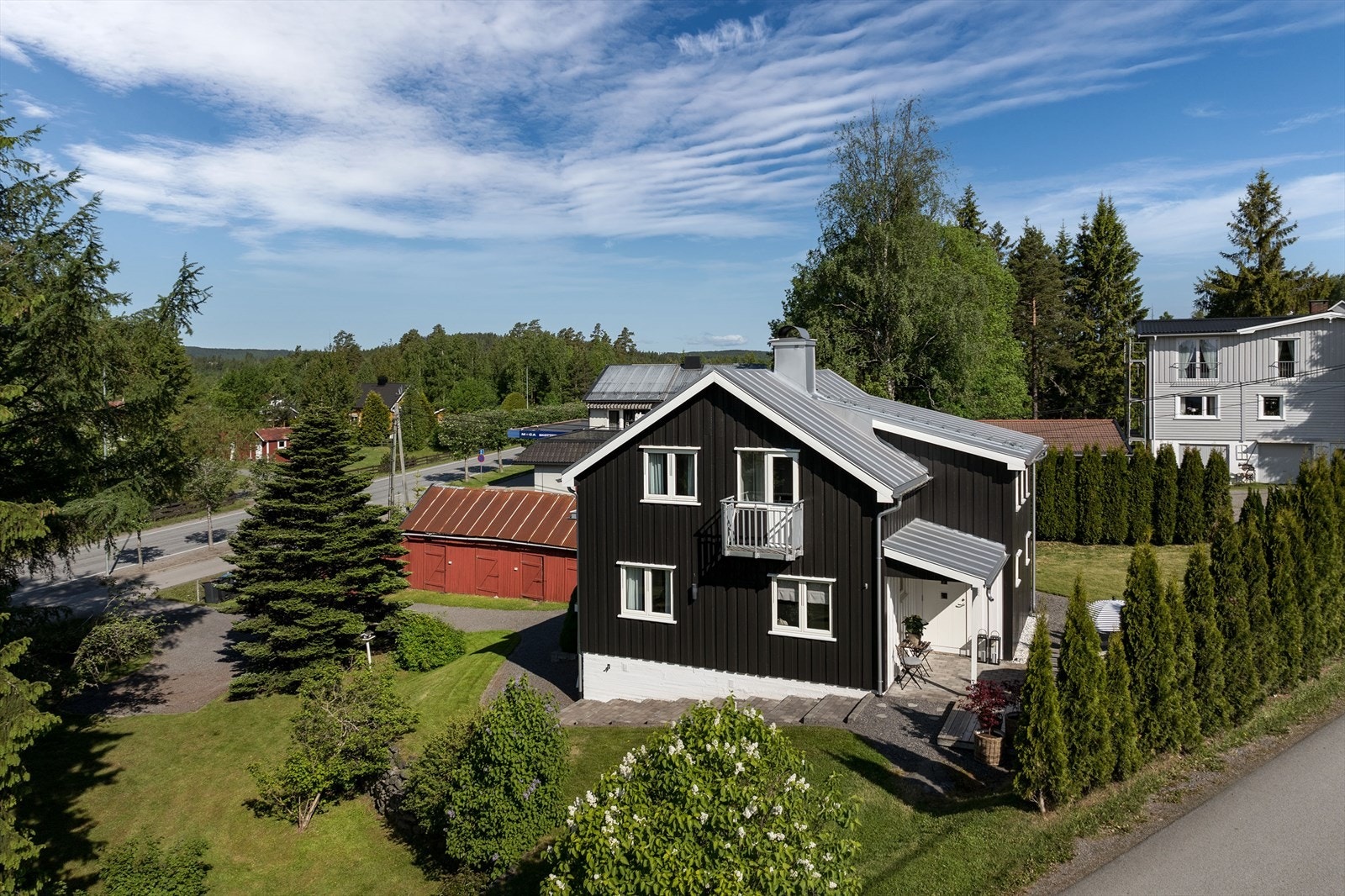 Eneboligen ligger på en pent opparbeidet tomt, skjermet med hekk og grønne omgivelser. Galleribilde