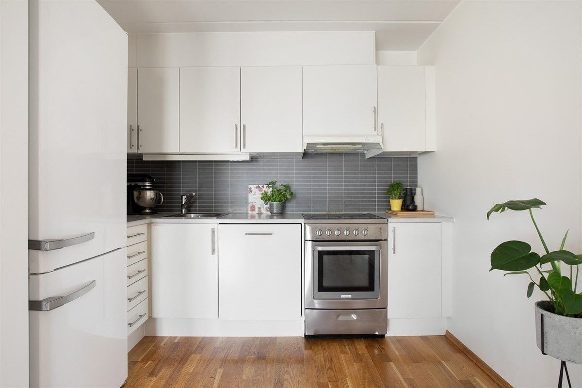 Lyst kjøkken med hvitevarer inkludert Galleribilde