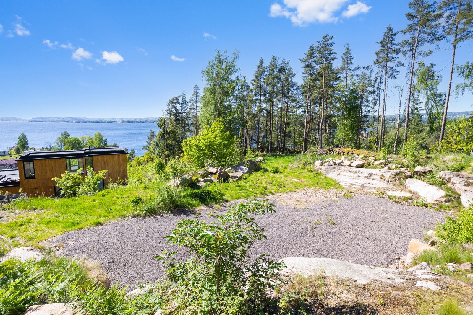 Tomten er relativt flat og opparbeidet med grus. Byggeklar med godkjente tegninger. Galleribilde