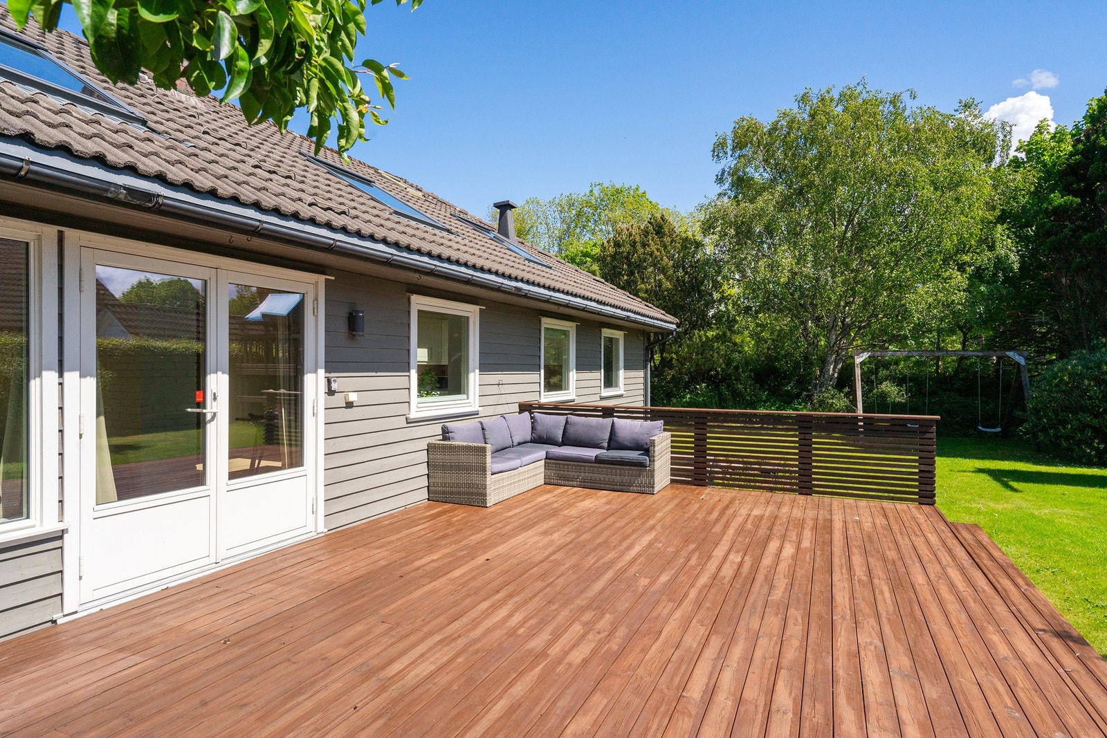 Fra stuen har man utgang til stort terrassedekke og hage. Galleribilde