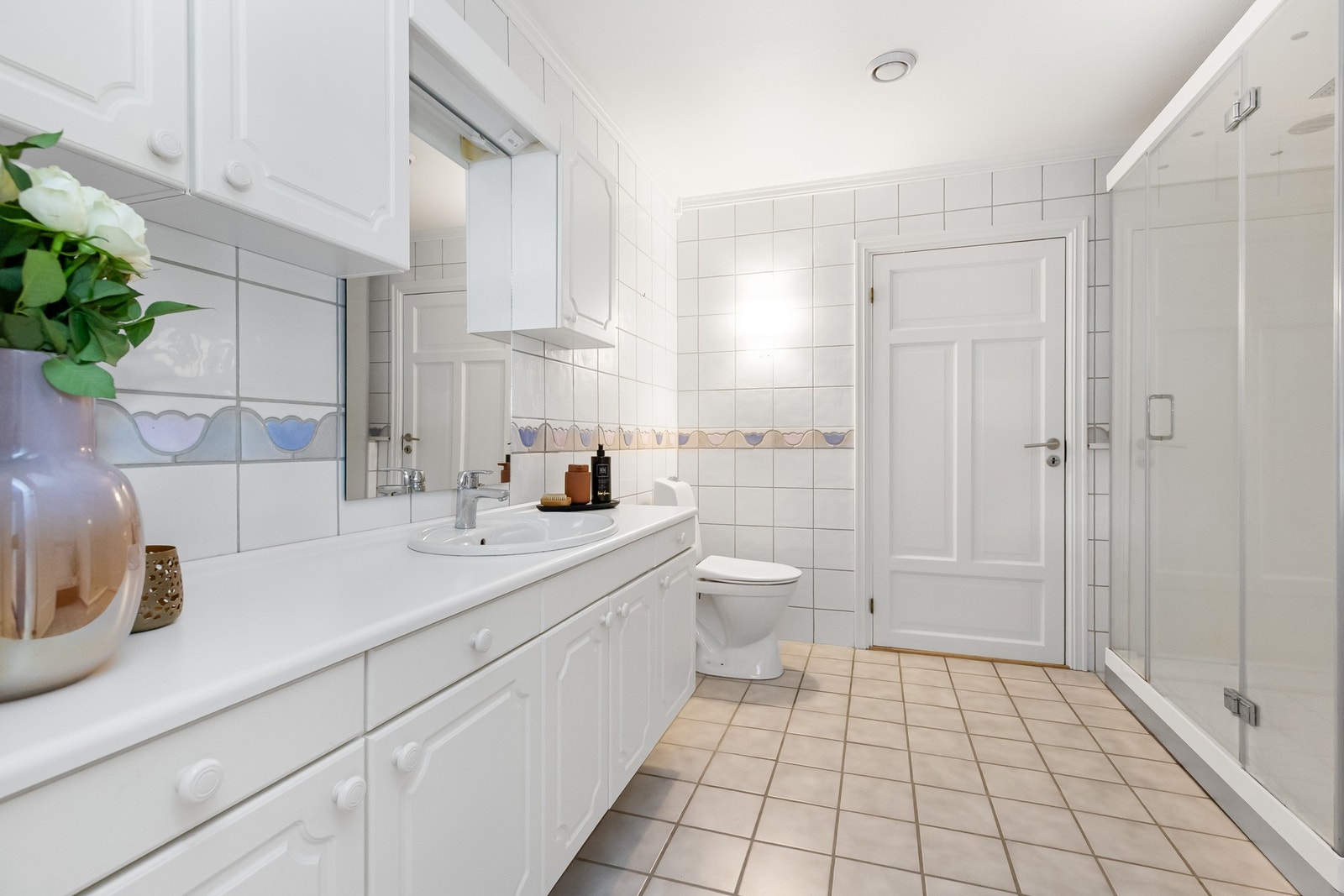 Stor innredning med god skapplass og nedfelt servant i benk. Dusjnisje som kabinett med romslig plass, gulvmontert toalett Galleribilde