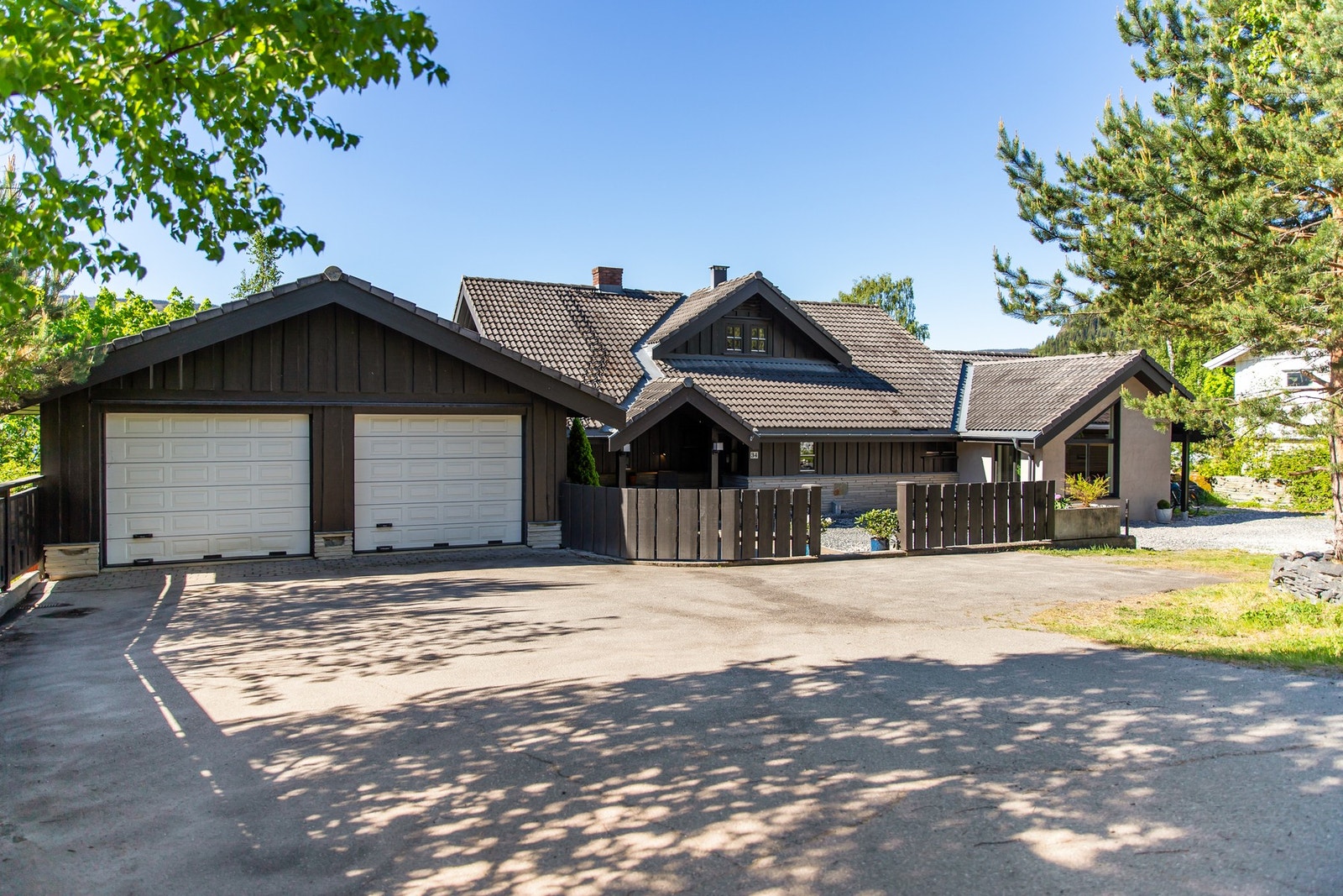 Inngangspartiet er belagt med brostein, og det er asfaltert adkomst samt steinlagte partier rundt boligen Galleribilde