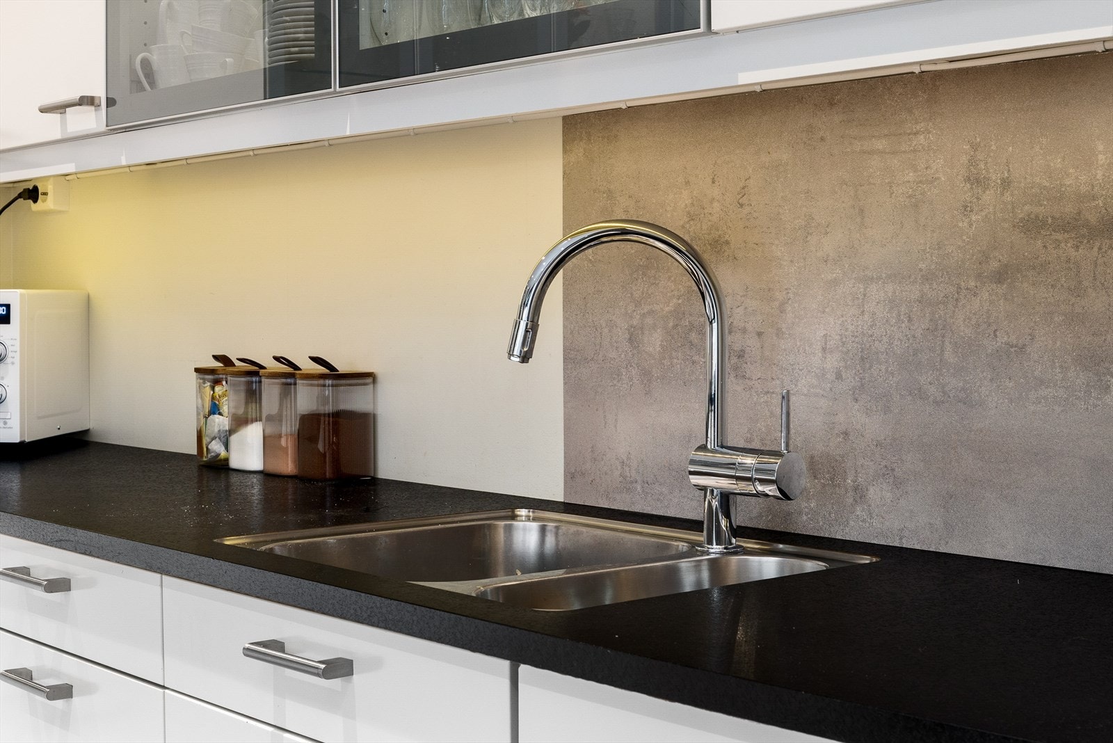 Benkeplaten i laminat er utstyrt med nedfelt oppvaskkum, og det er rikelig med både skap- og benkeplass - perfekt for både hverdag og selskap. Galleribilde