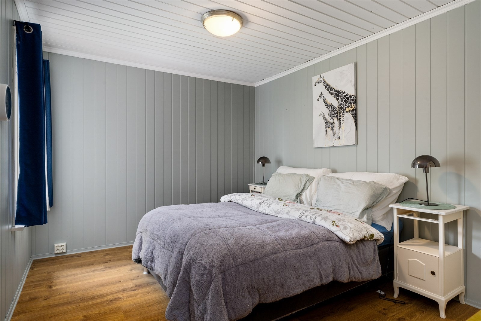 Hovedsoverommet ligger praktisk til i første etasje og fremstår som lyst og romslig. Rommet har gjennomgående pene, moderne gulv som gir en lun atmosfære, og veggene er malt i delikate, lyse toner som bidrar til en rolig og avslappende stemning. Galleribilde