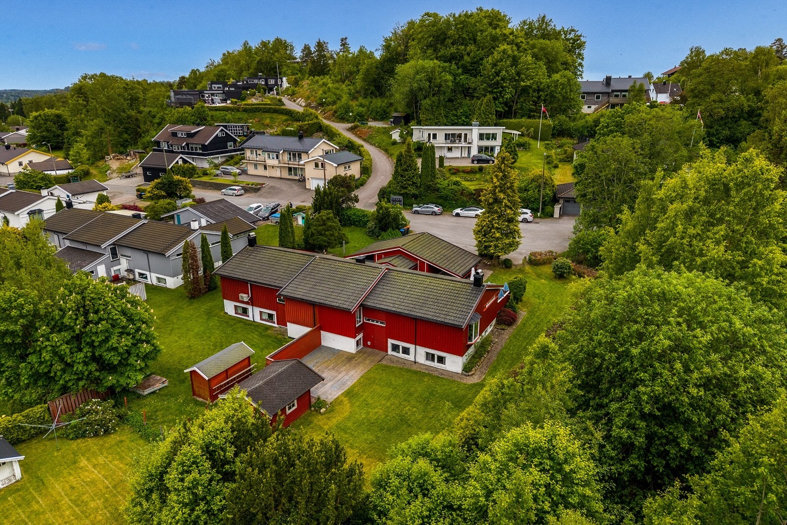 Den varierte beplantningen med prydbusker, trær og grøntområder gir både privatliv og en frodig, innbydende ramme rundt eiendommen. Galleribilde