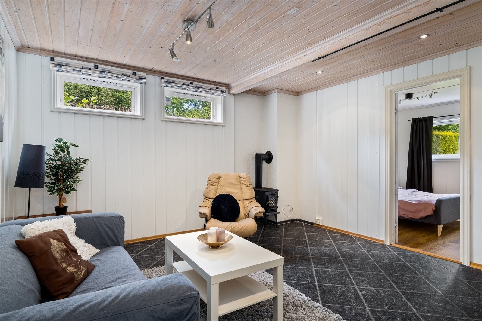 De lyse overflatene kombinert med lune detaljer gir en varm og behagelig atmosfære, og rommet oppleves som både koselig og romslig. Plasseringen i underetasjen gir en egen sone med fred og ro, perfekt for å trekke seg tilbake fra husets mer aktive soner. Galleribilde