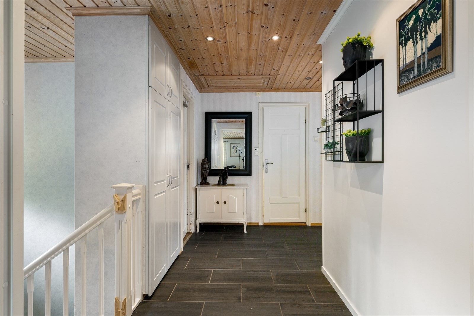 Lys og innbydende hall med trapp som fører ned til underetasjen, og gir en naturlig og praktisk forbindelse mellom etasjene. Galleribilde