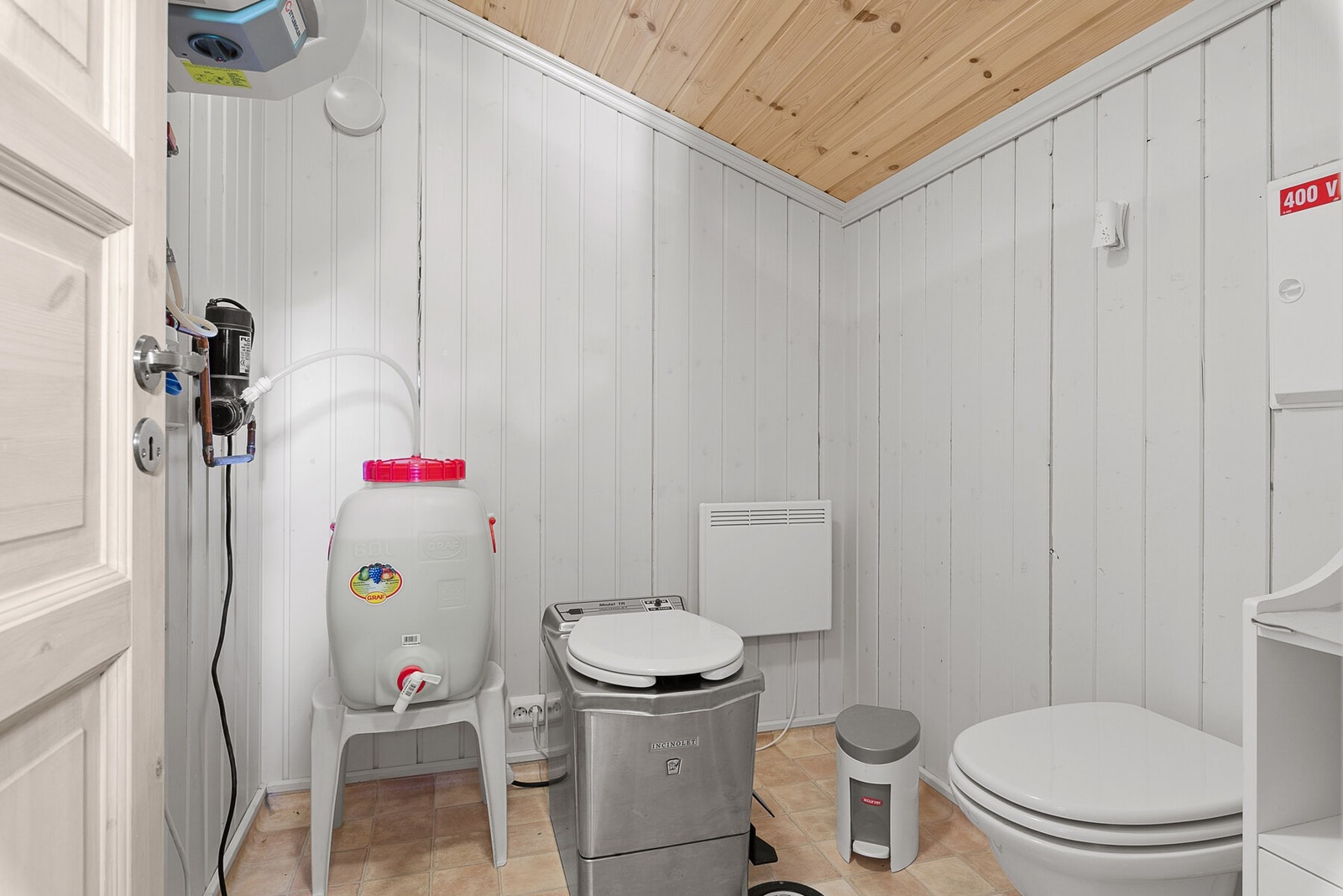 Separat og praktisk toalettrom med forbrenningstoalett og urinal. Galleribilde