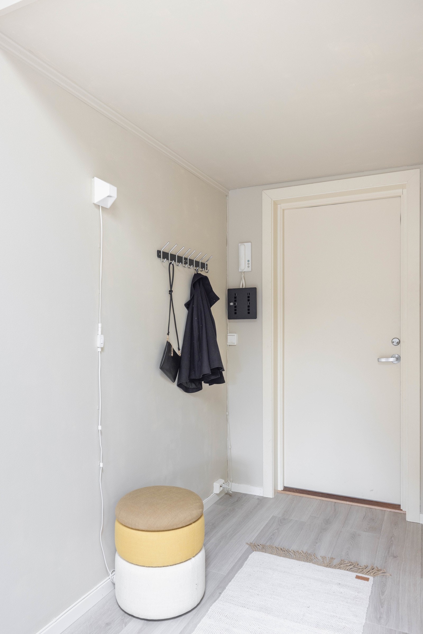 En praktisk entré med plass til klesoppheng. Det er porttelefon til ytterdør. Galleribilde