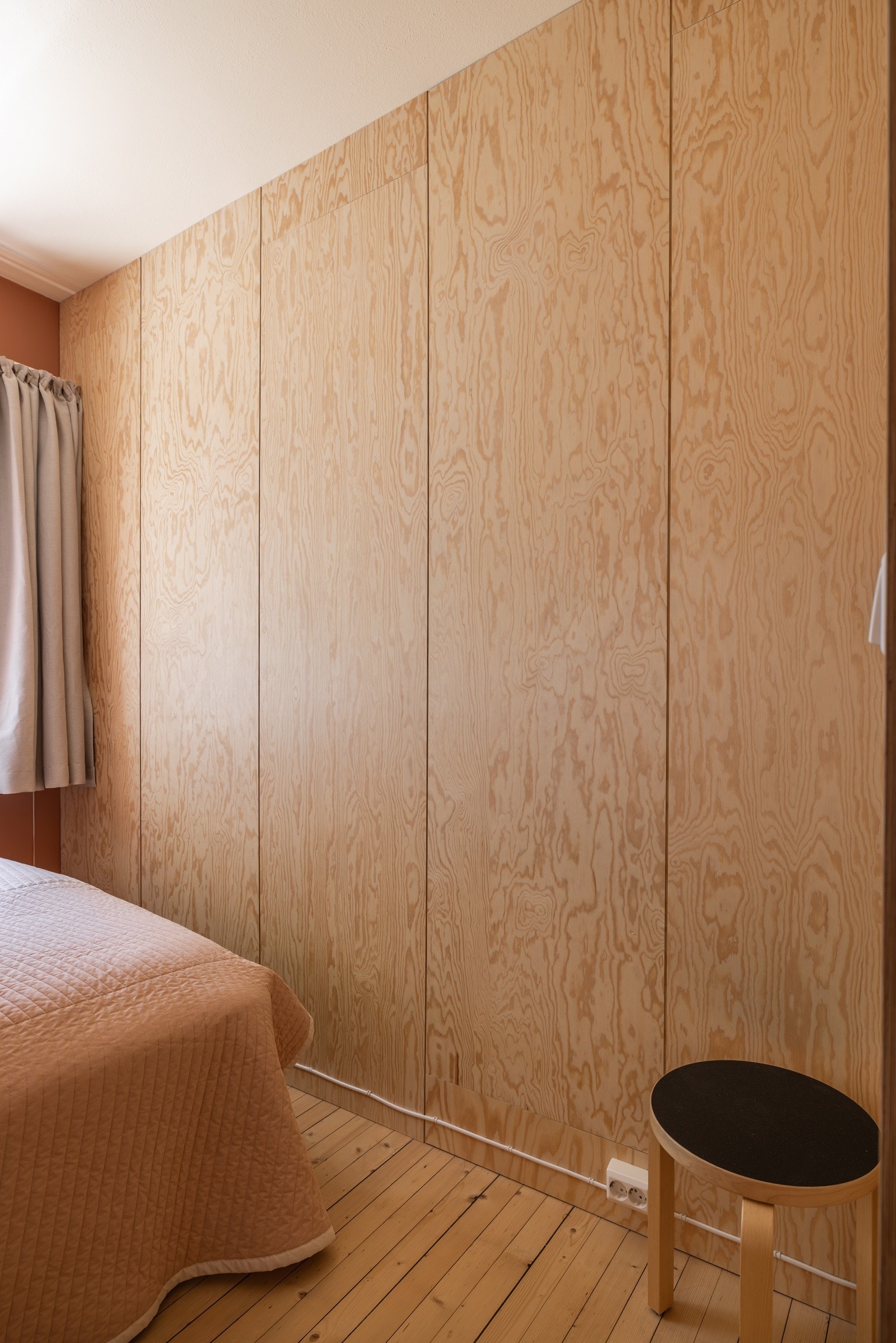 Nydelig soverom med lyse originale tregulv og glatte overflater malt i en fin farge kombinert med plater i av tre. Galleribilde