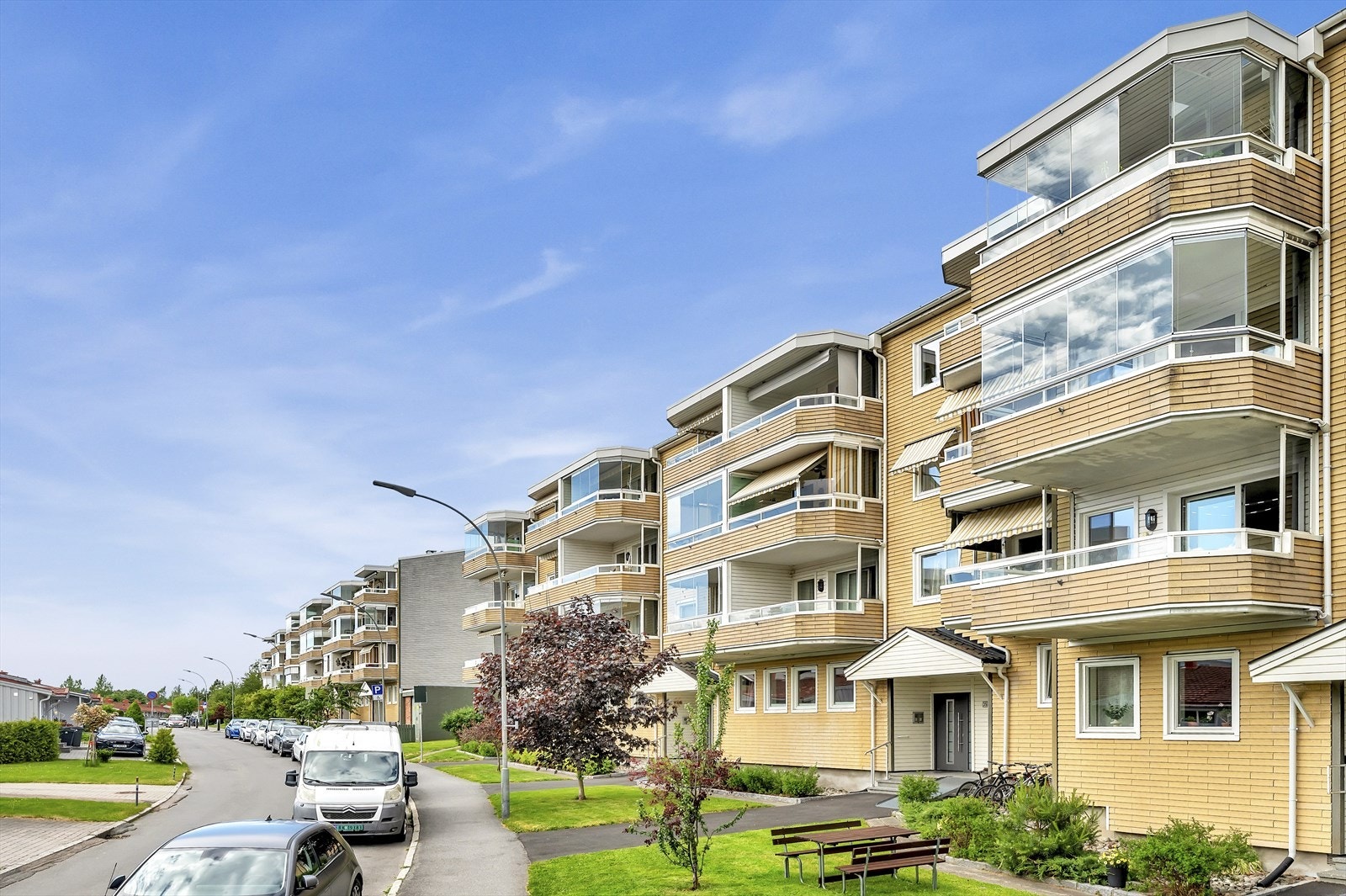 Fasade. Borettslaget har pent opparbeidede fellesarealer utenfor inngangen. Galleribilde