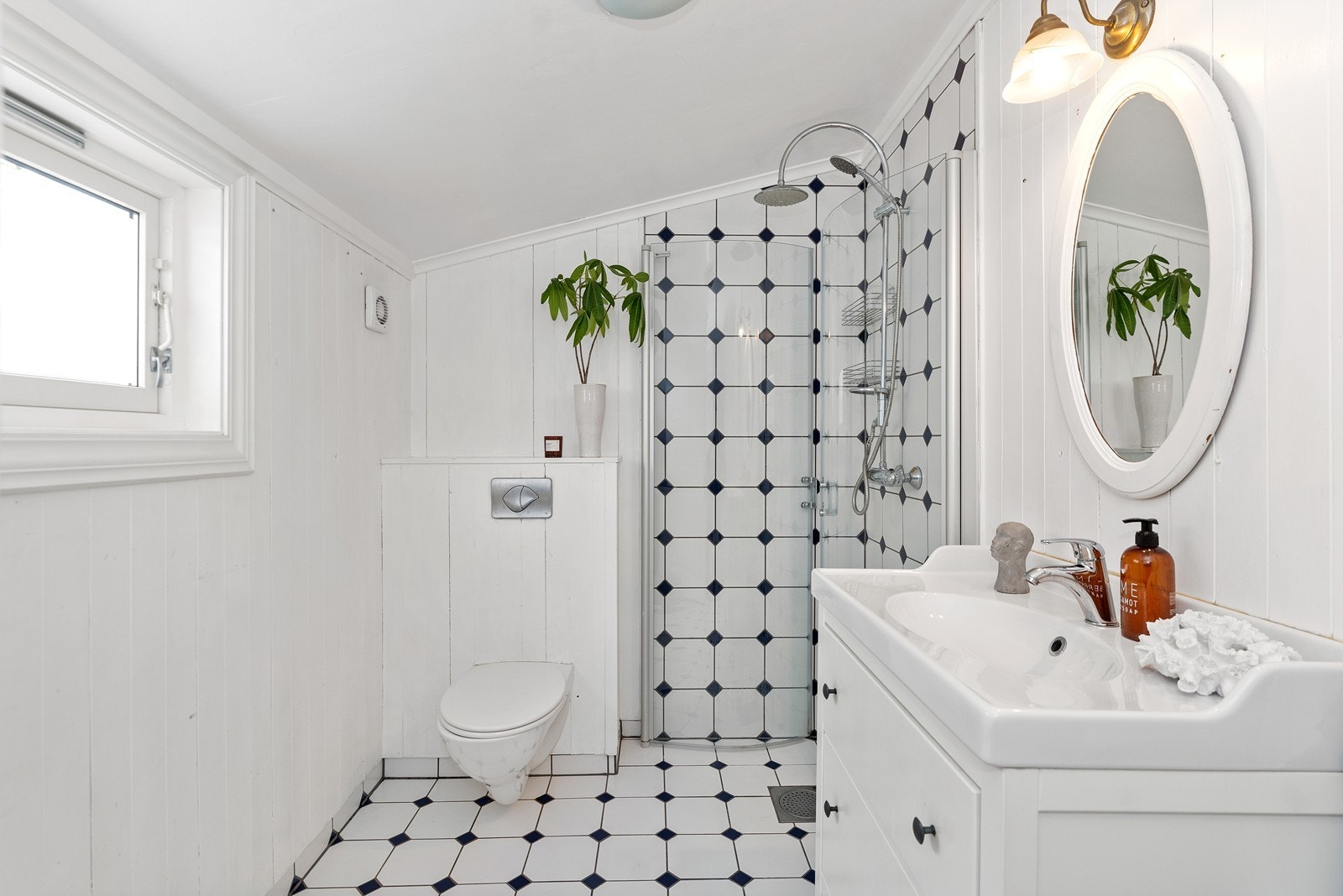 Badet er innredet med dusjnisje og opplegg for vaskemaskin Galleribilde