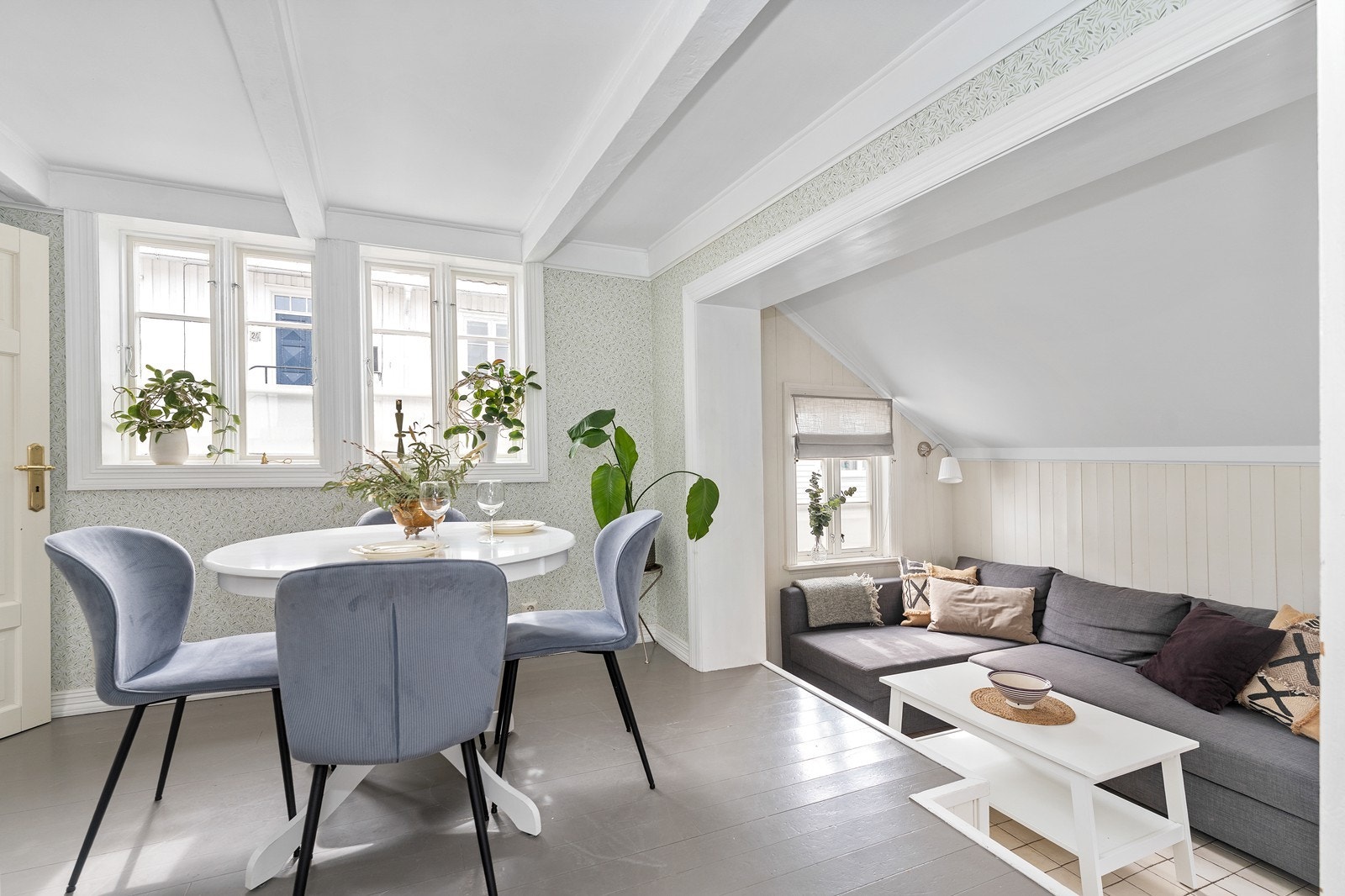 Stuen er innredet i to soner med sofakrok og plass til spisestuen - vinduer på flere sider som gir mye naturlig lys i rommene Galleribilde