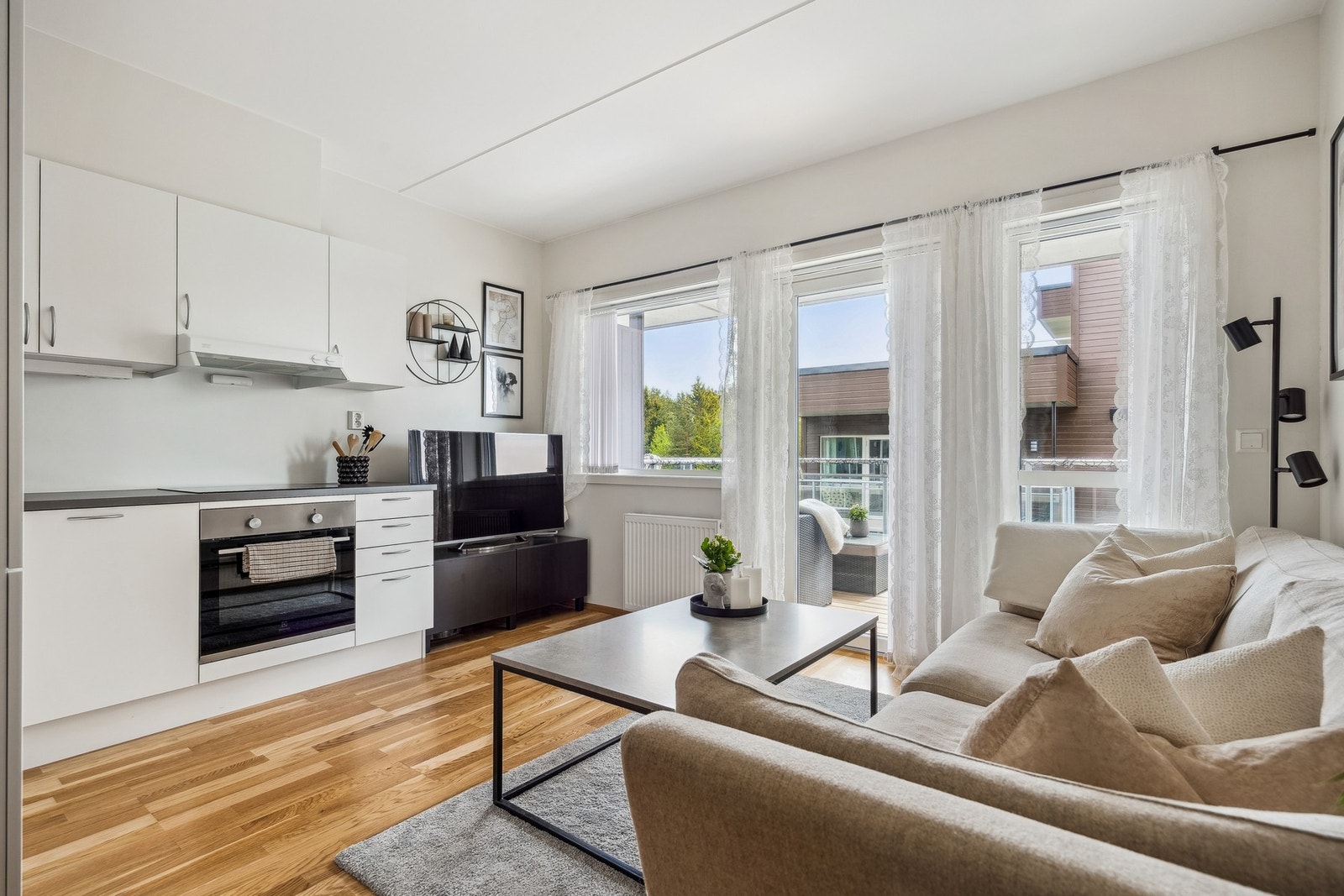 Åpen stue- og kjøkkenløsning med moderne interiør og lyse overflater. Her er det lagt til rette for et hyggelig hjemmemiljø! Galleribilde