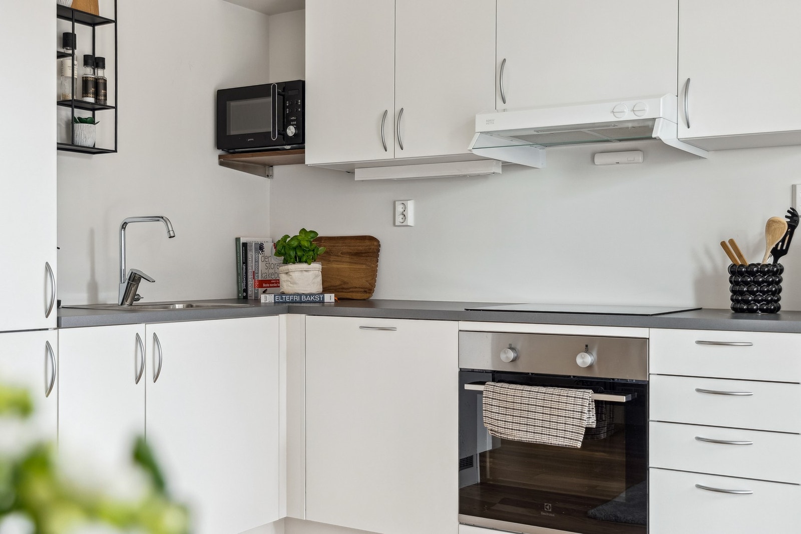 Flott kjøkken med integrerte hvitevarer som stekeovn, platetopp, oppvaskmaskin og kjøleskap med fryser. Ventilator i overskap som drives av det balanserte ventilasjonsanlegget. Galleribilde