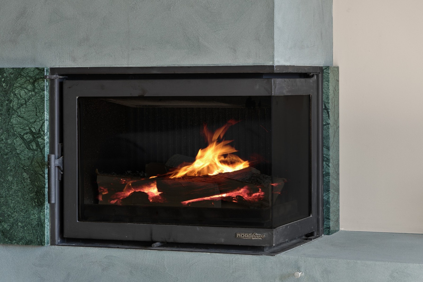 Peisovn plassert i stuen fra 2024 med montert vifte over skorstein. Galleribilde