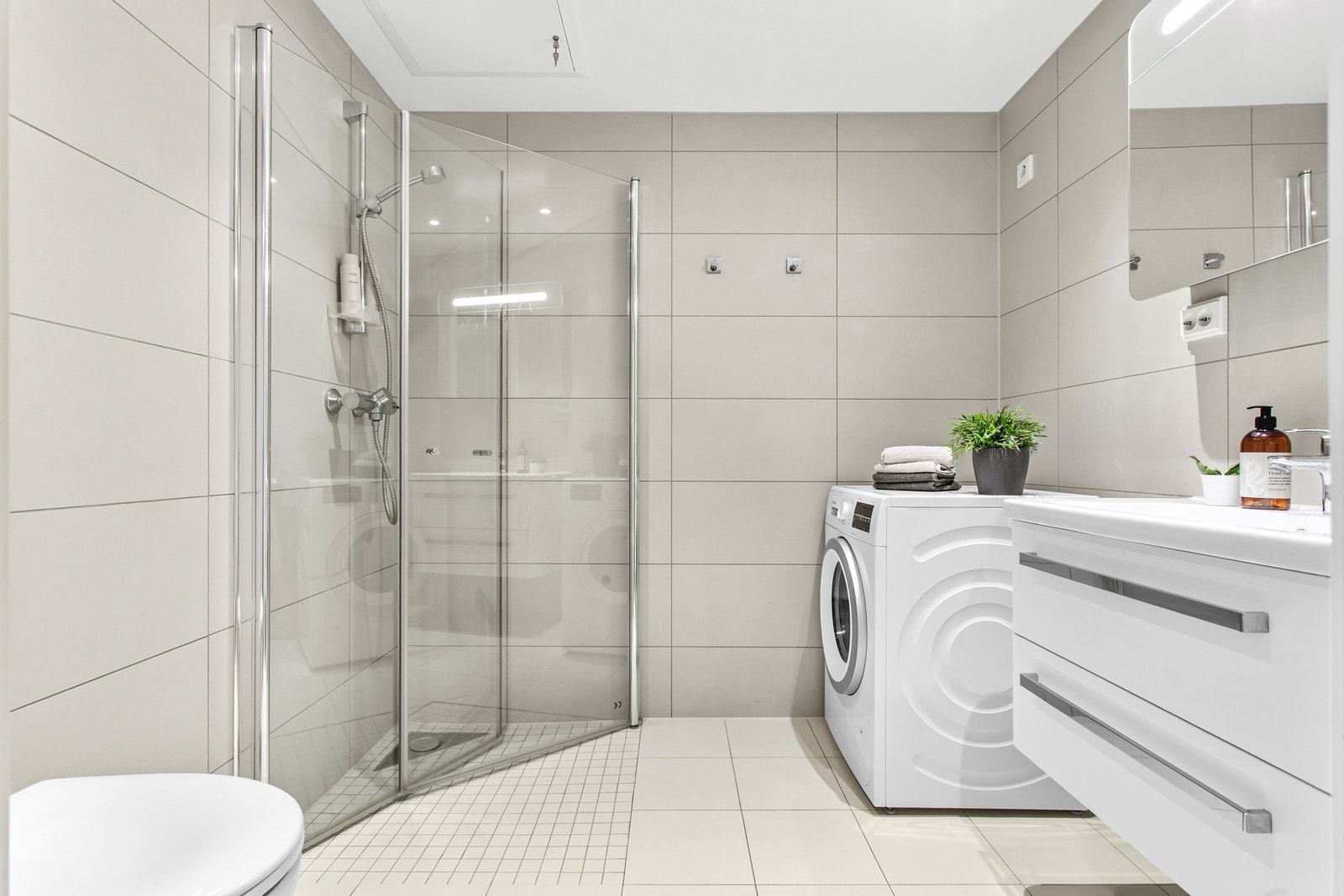 Badet har plass til både vaskemaskin og tørketrommel, som gjør det enkelt å organisere hverdagen. Galleribilde