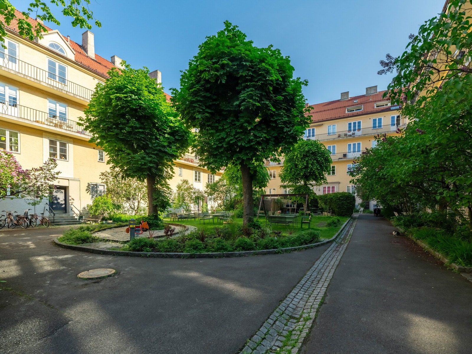 Borettslagets bakgård er fint opparbeidet med frodige grøntarealer til glede for beboerne. Galleribilde