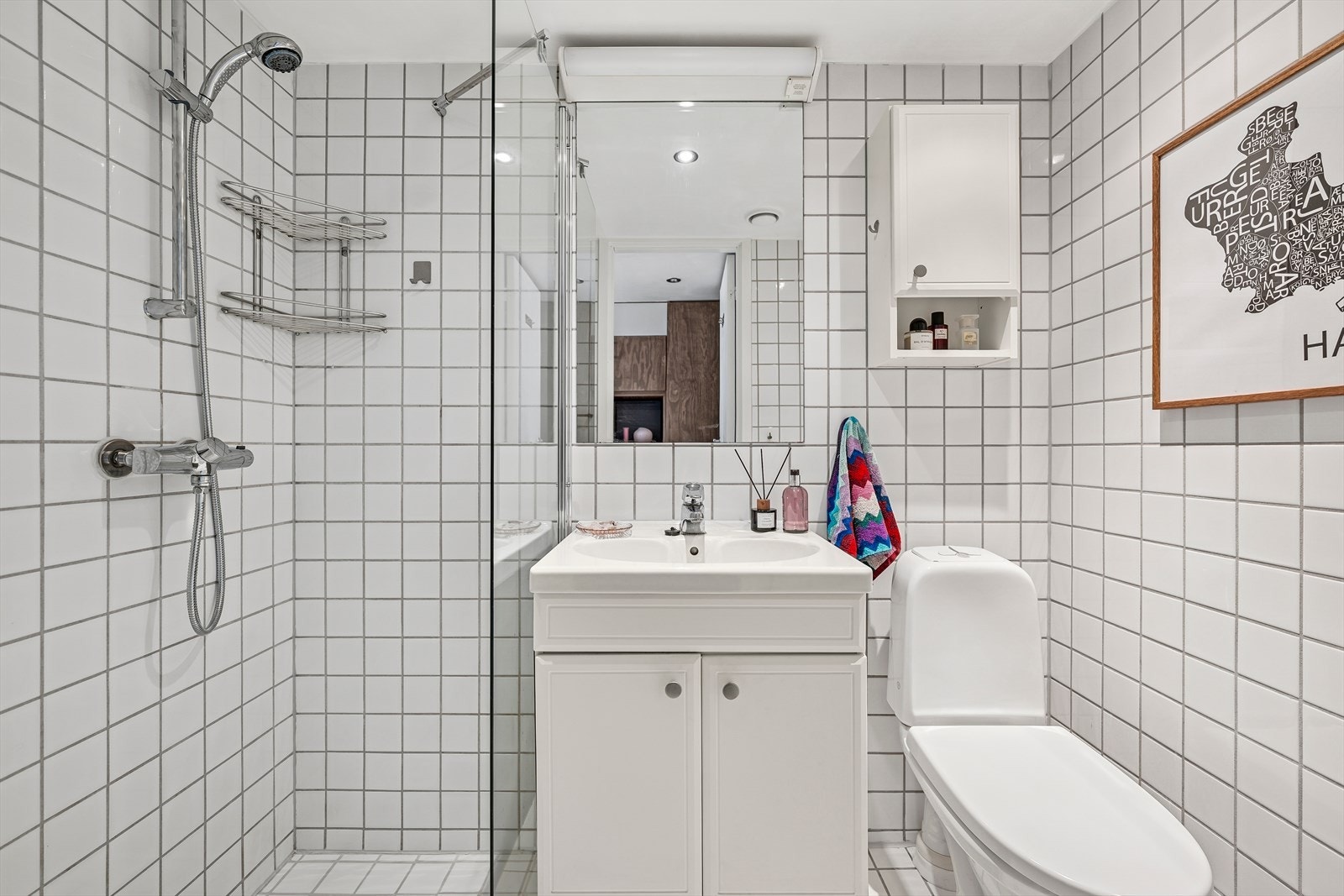Pent, flislagt baderom med fliser på vegg og gulv. Badet er utstyrt med varmekabler i gulv. Galleribilde