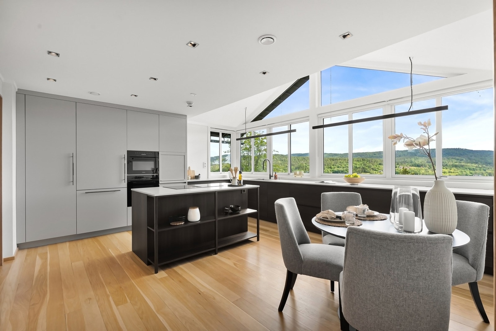 Delikat kjøkken med kjøkkenøy, åpen peis og spiseplass Galleribilde