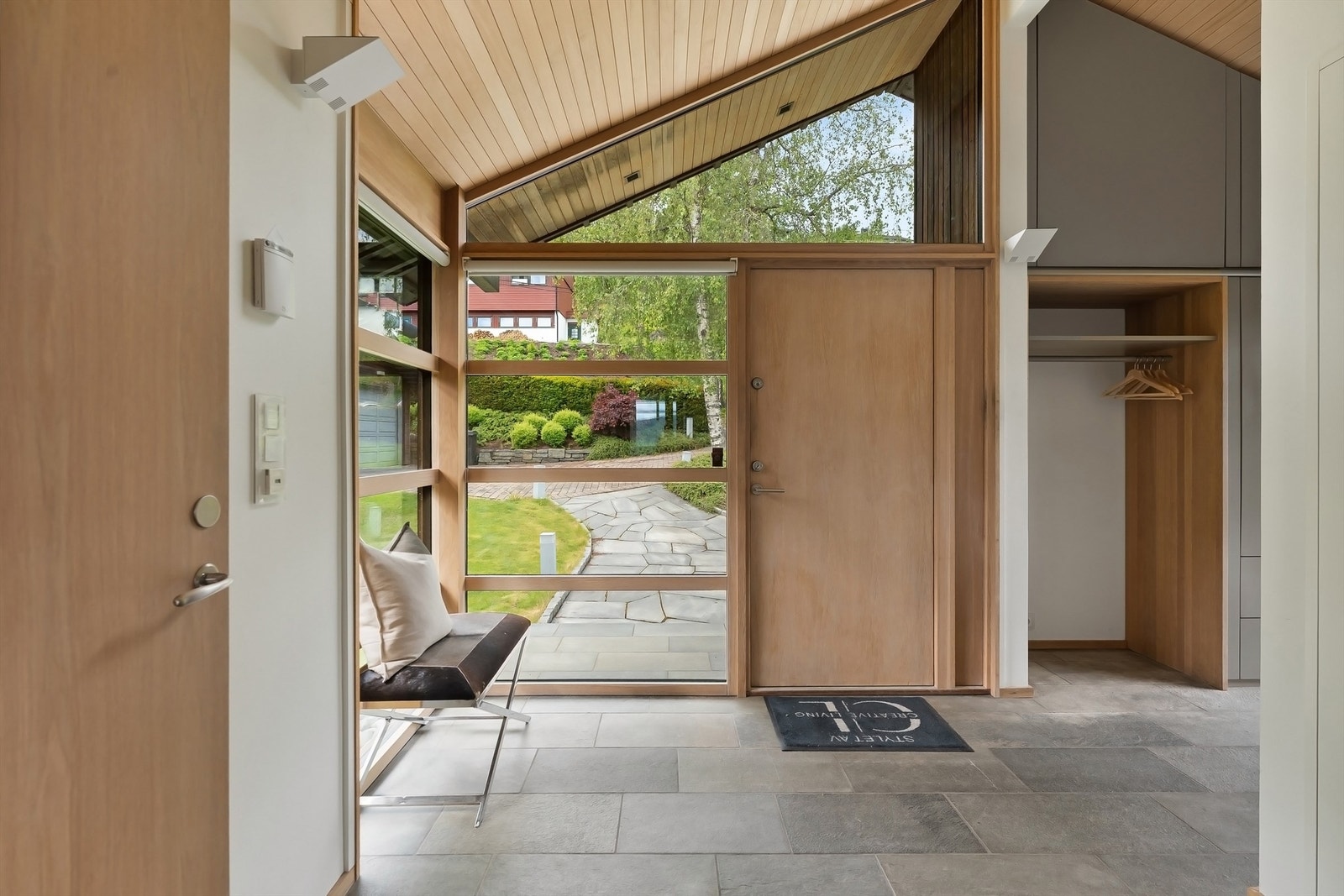 Stor, innbydende entré med god plass for yttertøy og sko. I entréen er det elektrisk oppvarmet skifergulv og spiler av osp i himling som gir en eksklusiv og innbydende velkomst Galleribilde